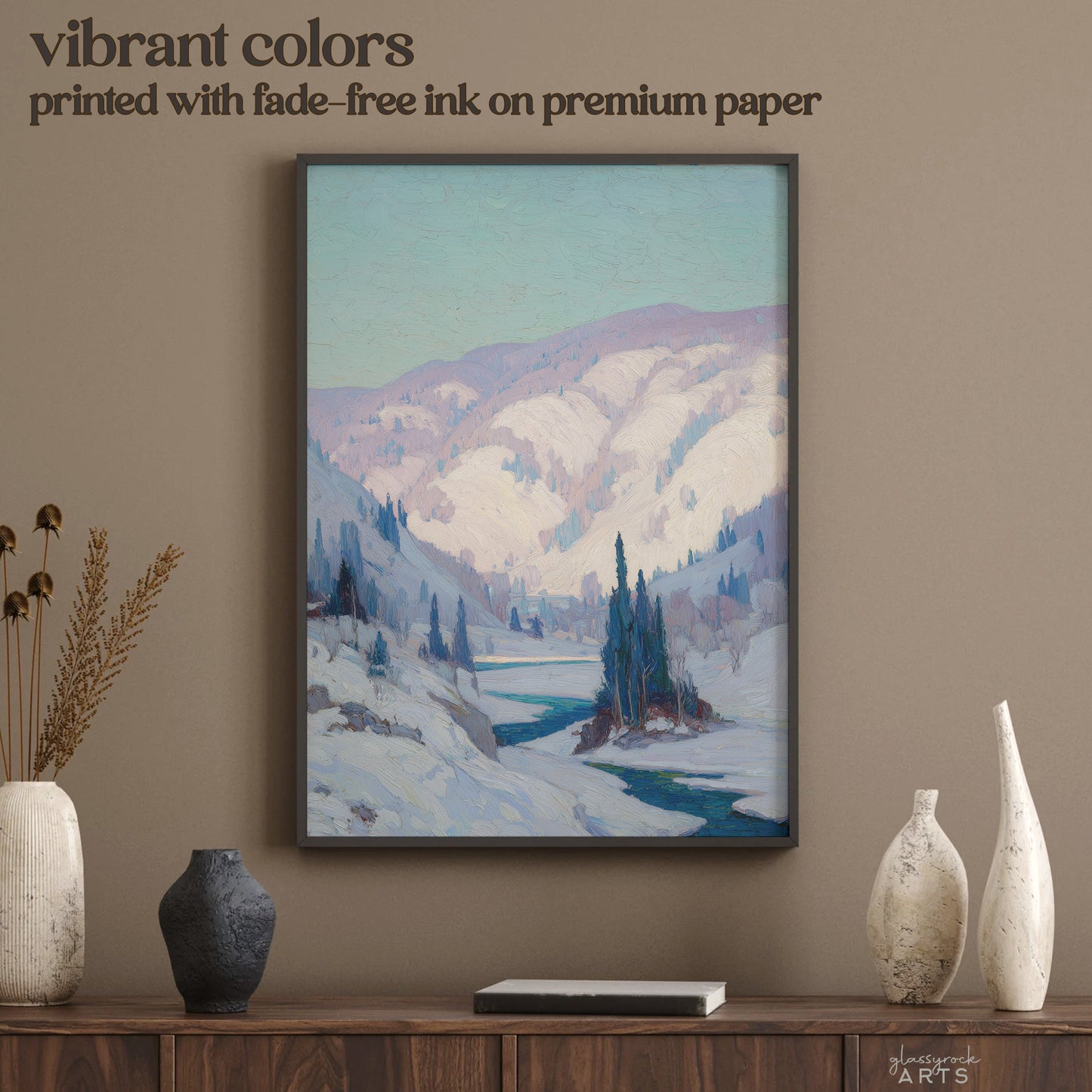 Framed mountain landscape print on a wall above a wooden console table with decorative vases.