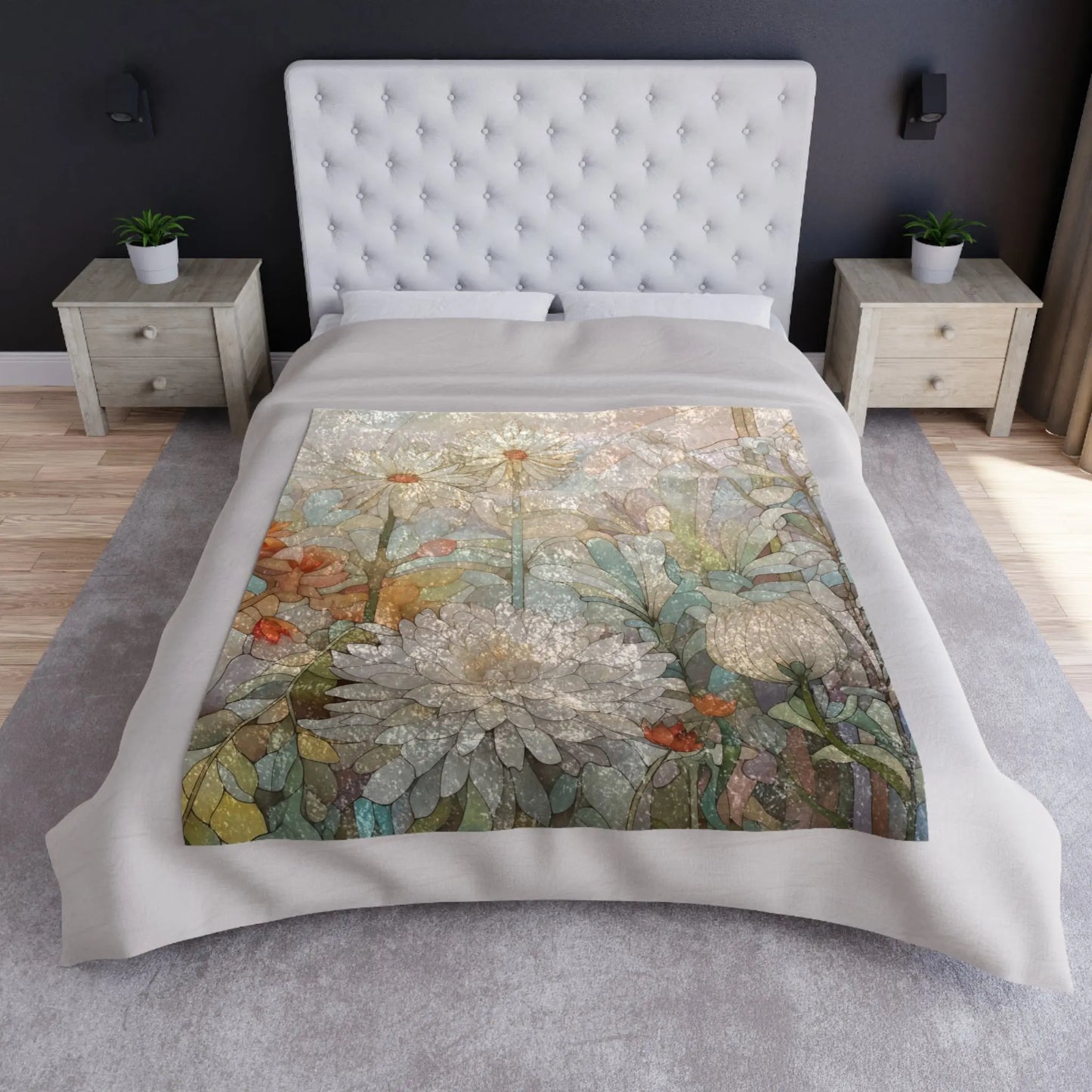 The bed has a tufted headboard and is adorned with a white duvet with a floral design. A vibrant Stained Glass Spring Flowers Crushed Velvet & Fleece Blanket complements it, flanked by wooden nightstands each holding a small green plant. The room features grey carpet and dark walls.