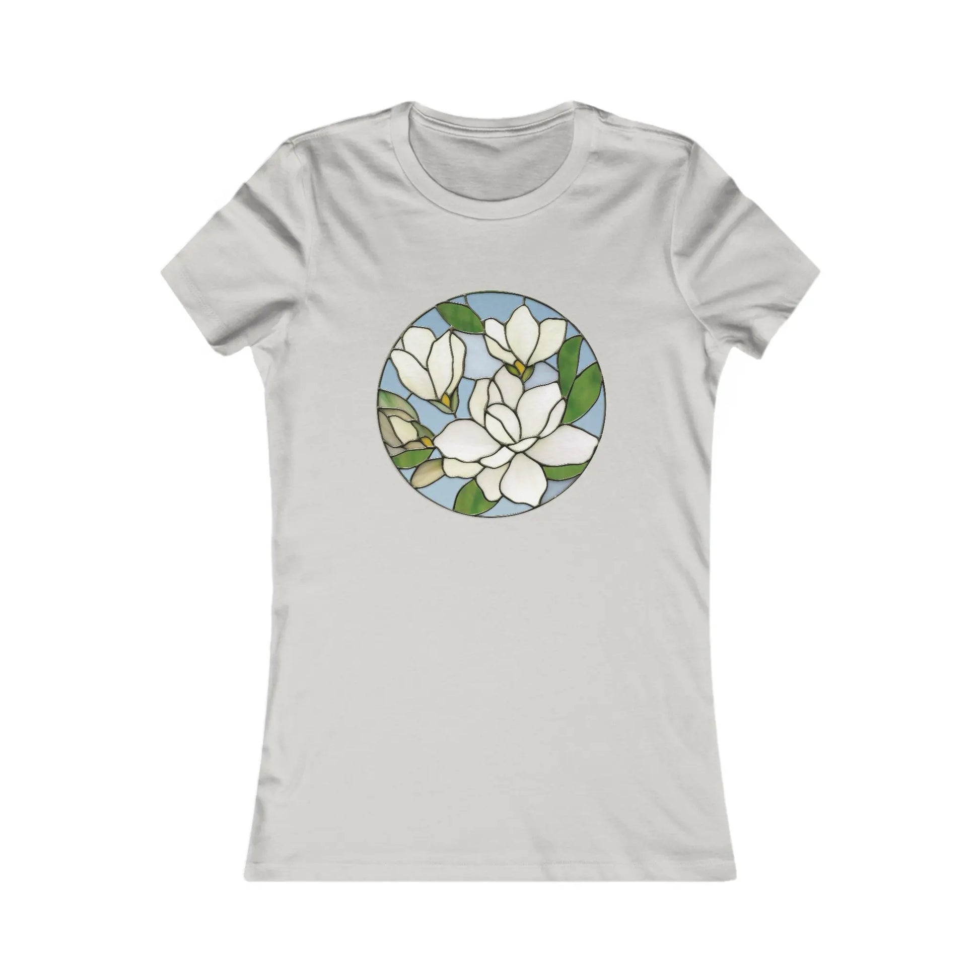 The Stained Glass Magnolia Womens Tee Shirt features a circular design with white magnolia flowers and green leaves on a light blue background. This beige T-shirt offers a comfortable fit and is an eye-catching addition to sustainable clothing.