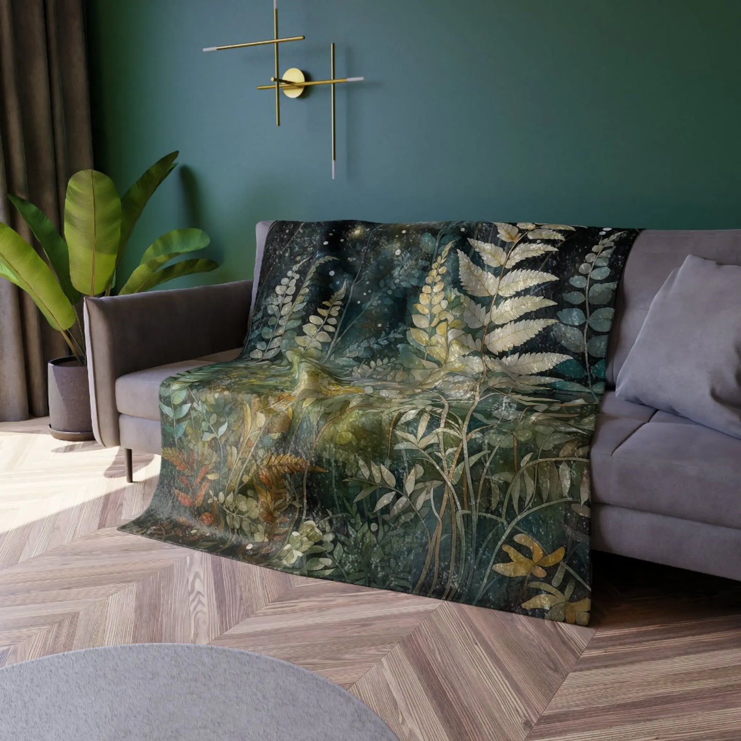 A cozy living room showcases a gray sofa adorned with the Stained Glass Midnight Ferns Crushed Velvet Blanket, featuring ferns and leaves. Green walls with minimalist golden decor, lush corner plants, and an elegant stained glass design cast colorful patterns throughout.