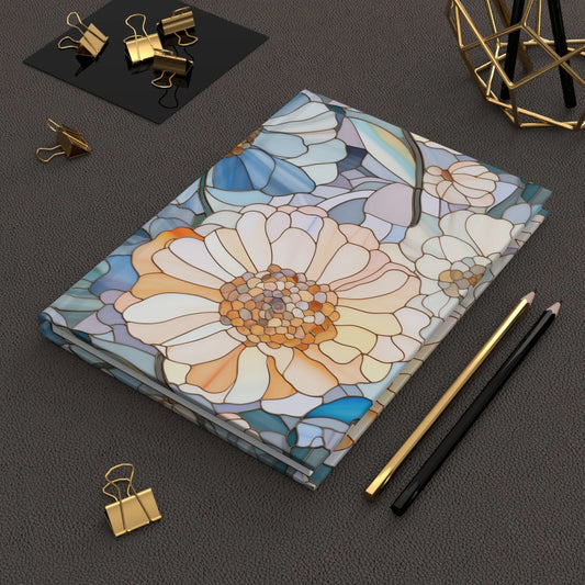 The Stained Glass Flowers Hardcover Journal sits on a textured surface with a gold and black pencil, surrounded by gold paperclips and a geometric metal sculpture, creating an exquisite custom arrangement.