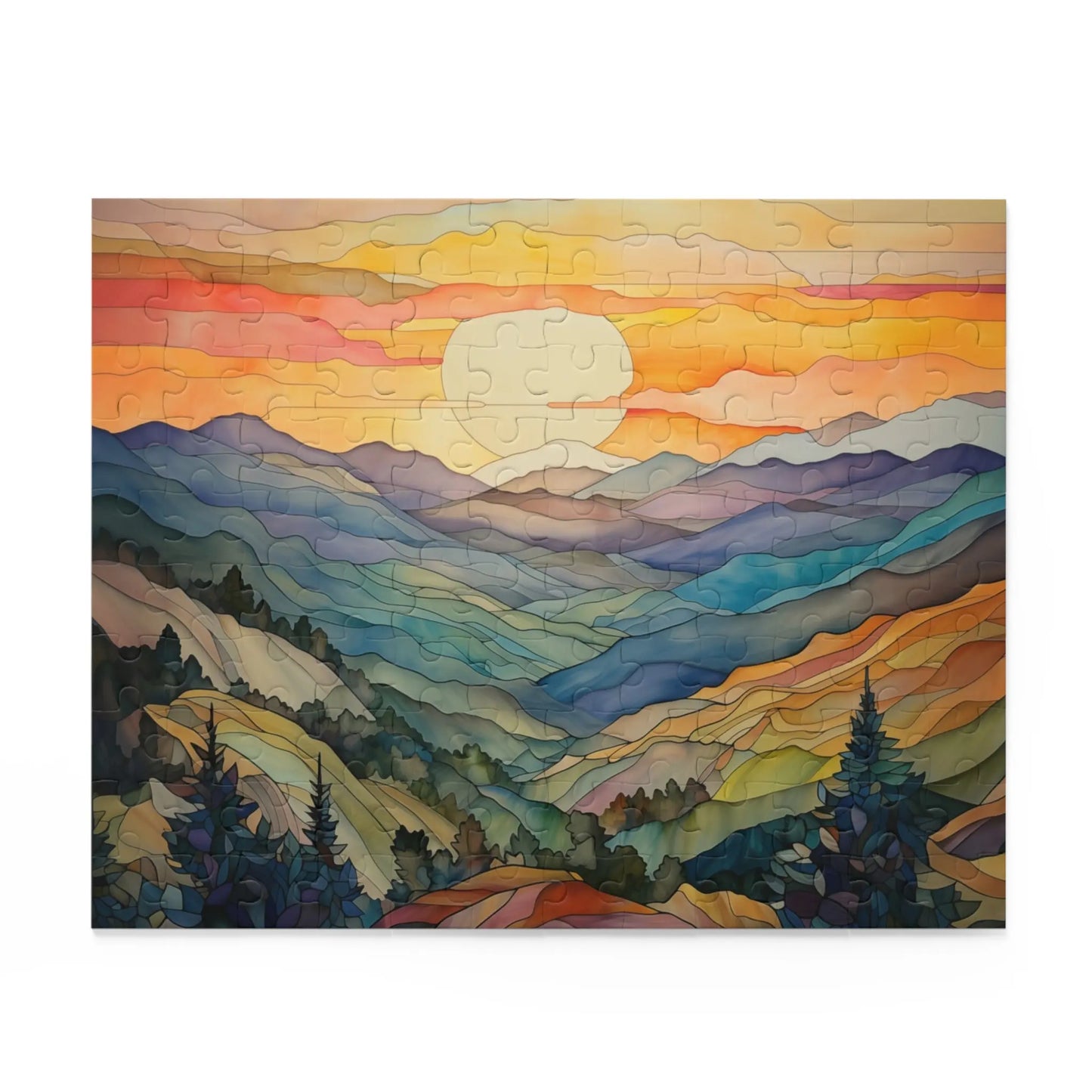 The Sunset Mountains Jigsaw Puzzle showcases a colorful landscape with rolling hills, a vibrant setting sun, and sky in stained-glass shades of orange, yellow, and pink. Blues and greens cover the hills with pine trees dotting the foreground – an ideal gift for any nature lover.