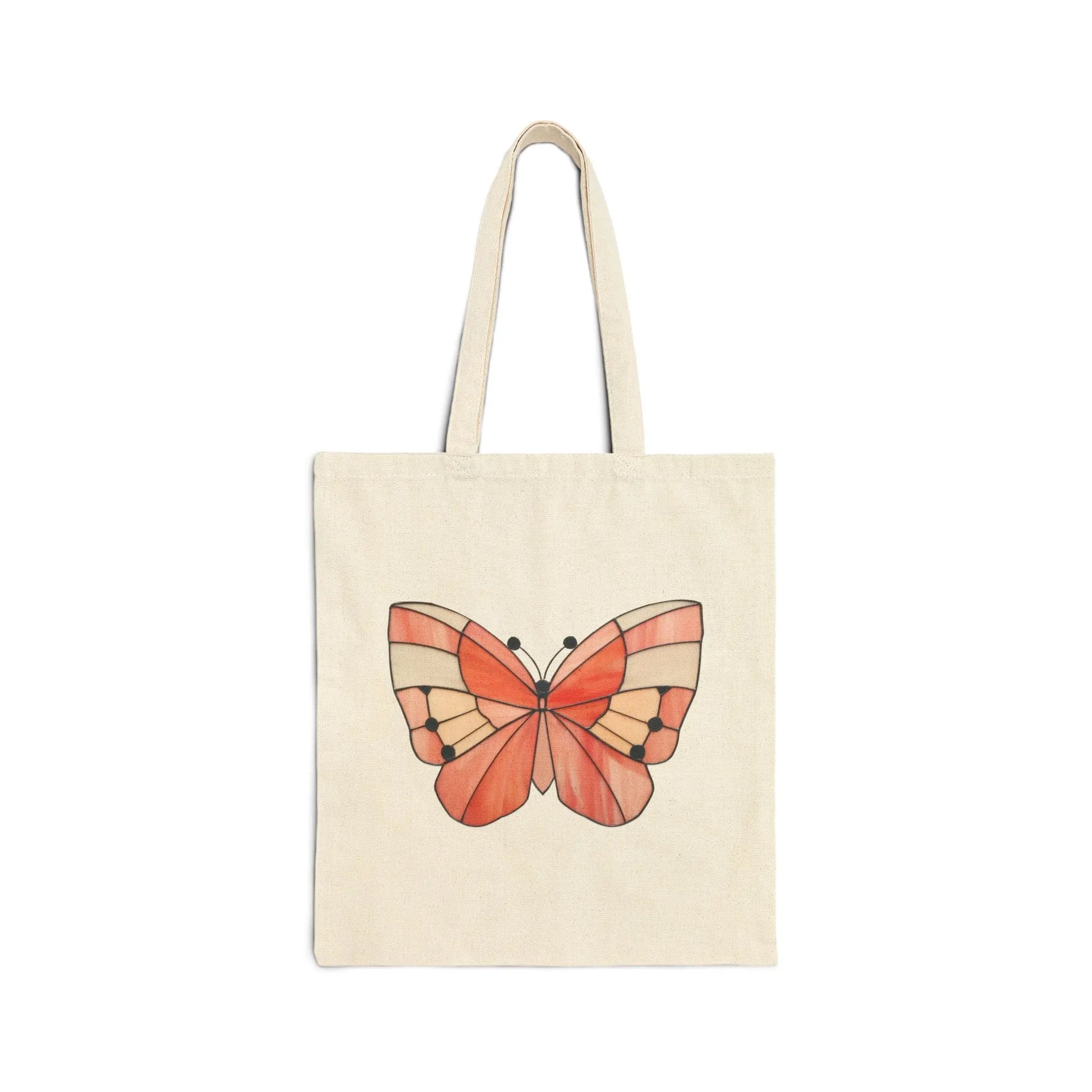 The Stained Glass Spring Butterfly Cotton Canvas Tote Bag features a cream-colored design with an orange butterfly and black accents on its wings, reminiscent of stained glass, set against a white background.
