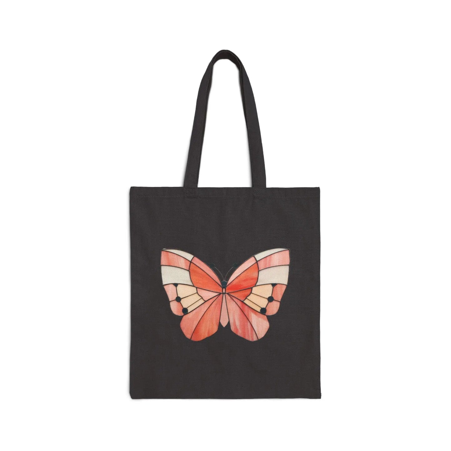 The Stained Glass Spring Butterfly Cotton Canvas Tote Bag showcases an original butterfly design in vibrant red, orange, and cream on black accents. The striking image is set against a plain white background, creating a stunning effect.