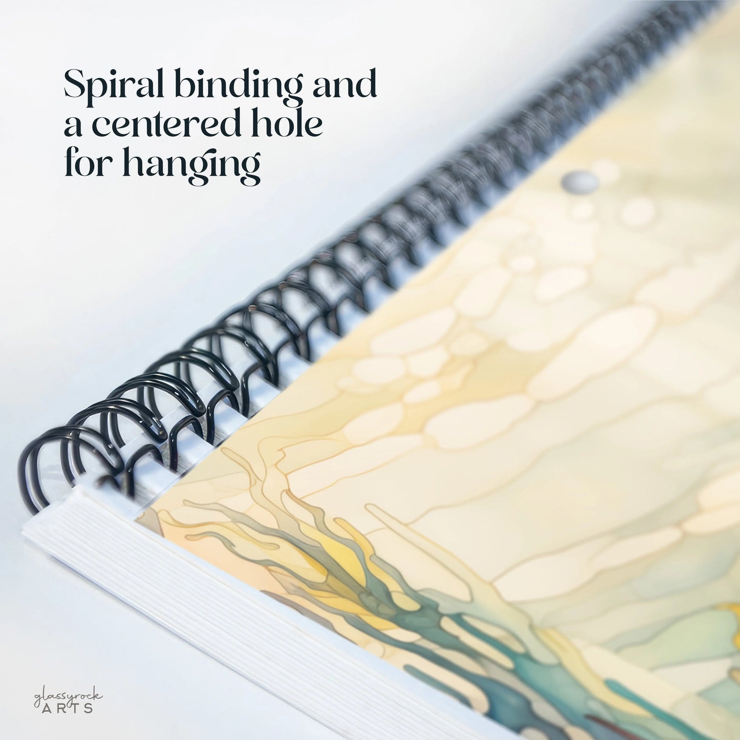 Close-up of the 2025 Ocean Life Large Wall Calendar with spiral binding and a centered hole for hanging, featuring abstract designs on its pages.