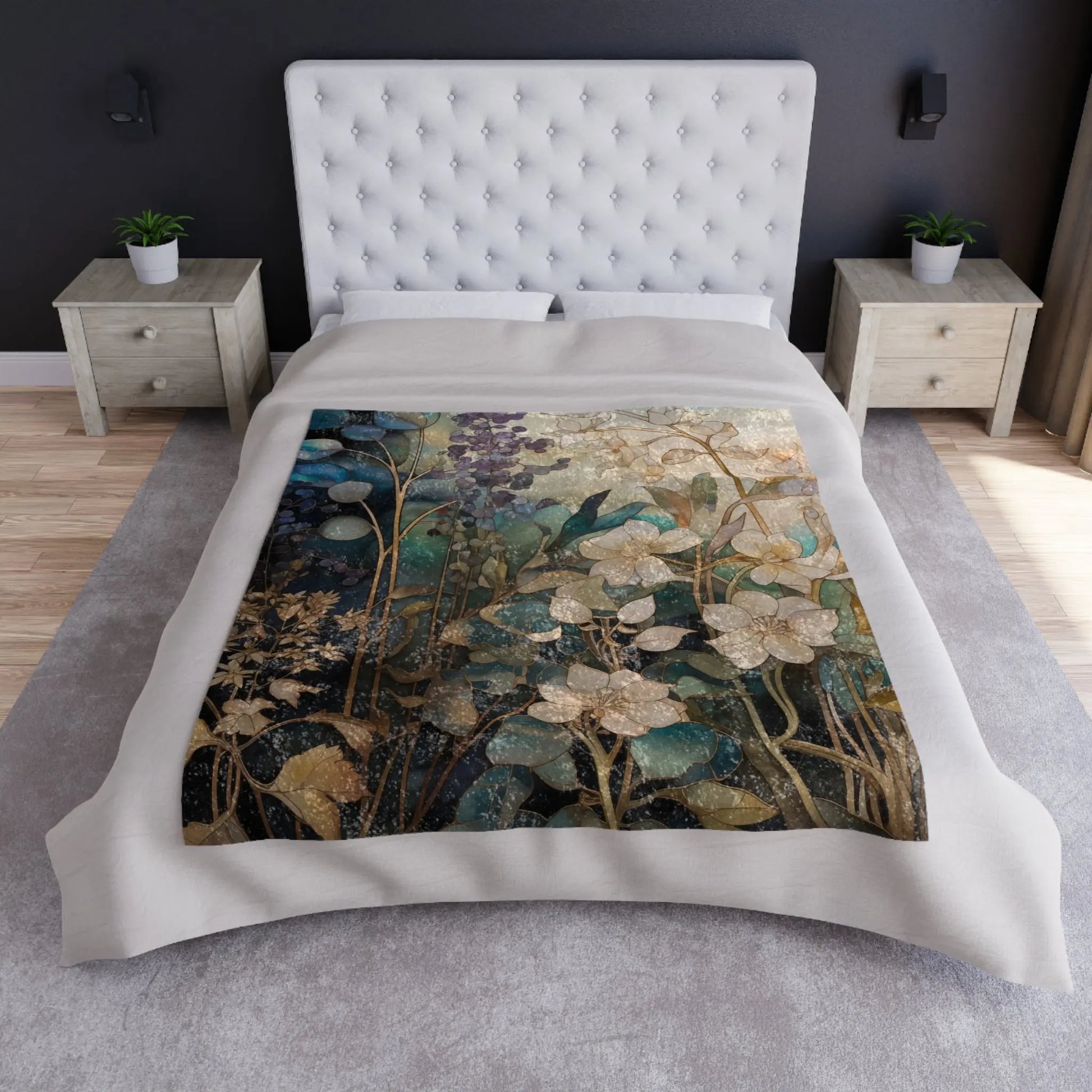 A stylish bedroom features a white tufted headboard and wooden nightstands, with a Stained Glass Midnight Flowers crushed velvet and soft fleece blanket in shades of green, blue, and gold. A soft gray carpet enhances the rooms luxurious feel.