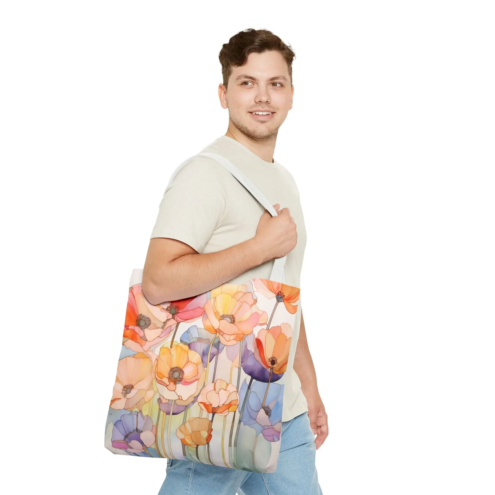 A person in a light-colored t-shirt and jeans carries a Stained Glass Poppy Flowers Tote Bag, made from durable polyester with vibrant orange, yellow, and blue floral designs. Theyre smiling and looking to the side.
