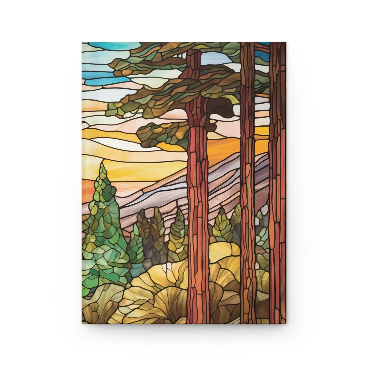 The Stained Glass Sequoia Forest Hardcover Journal features a serene forest scene with towering trees and a mountainous backdrop, highlighted by sunset hues that beautifully capture natures splendor.