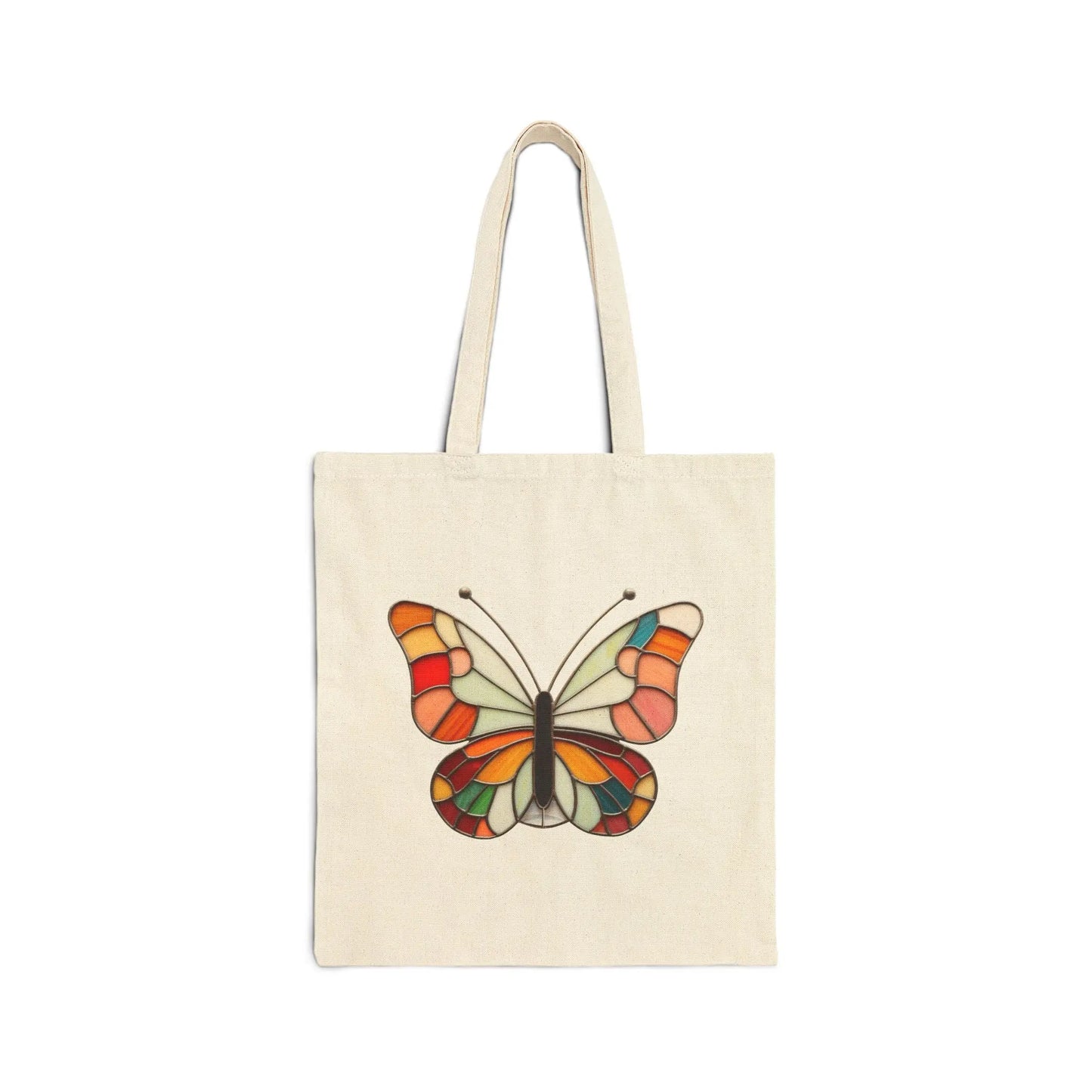 The Stained Glass Groovy Butterfly Cotton Canvas Tote Bag features a beige canvas with vivid shades of orange, yellow, red, and green in a stained glass-style butterfly design on a crisp white background.