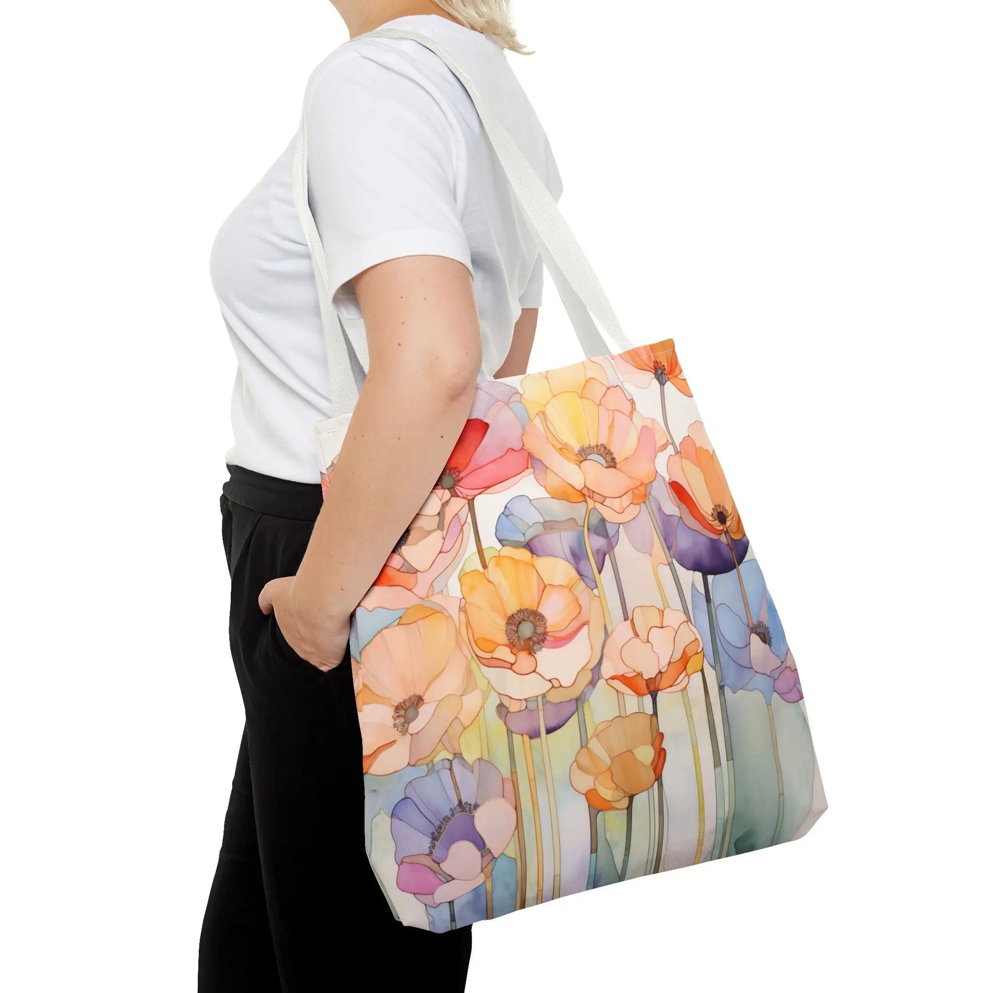 Against a plain white backdrop, someone showcases the durable polyester of the Stained Glass Poppy Flowers Tote Bag, donning a white t-shirt and black pants, highlighting its vibrant, artistic floral design.