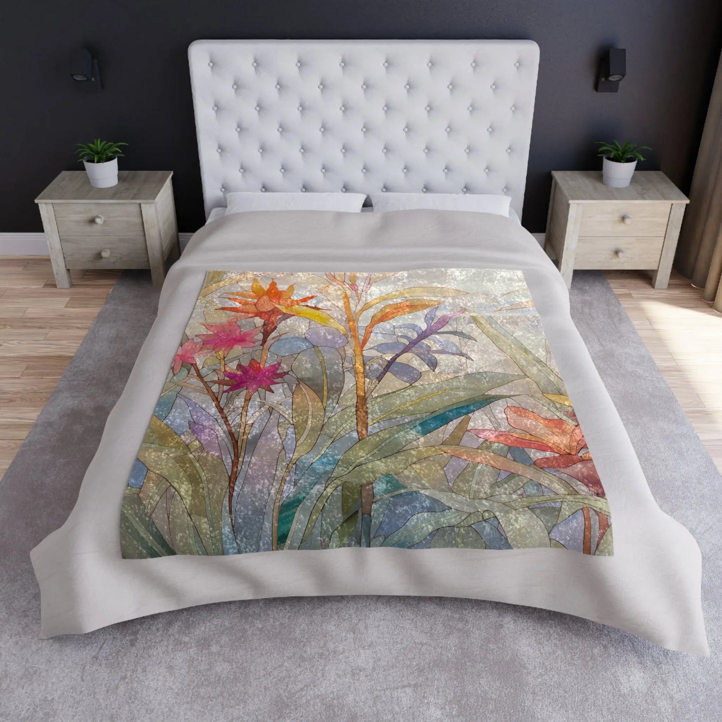 A bed with a Stained Glass Tropical Flowers Crushed Velvet & Fleece Blanket - 50x60, featuring abstract flowers and leaves. It has a tufted white headboard, crushed velvet pillows, and two light wooden nightstands with decor, giving the room a modern, minimalistic design.