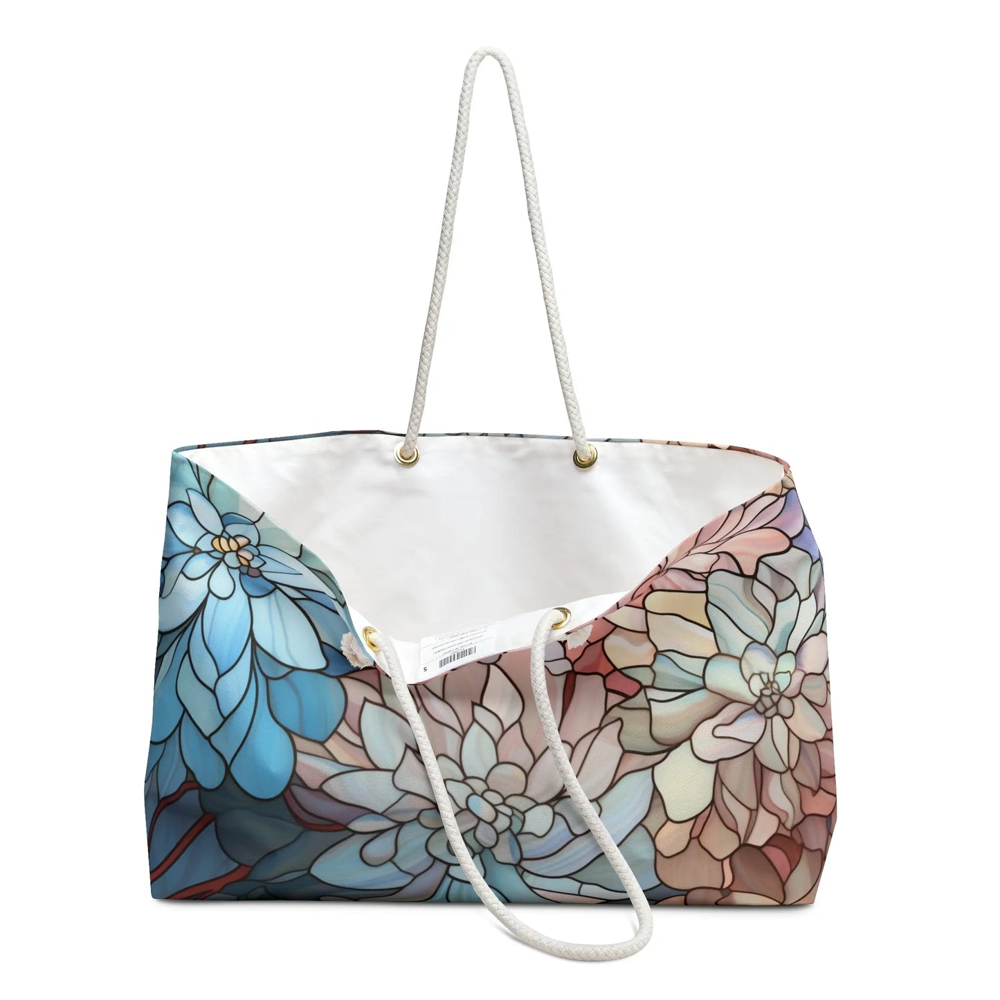The Stained Glass Dark Flowers Oversized Tote Bag features a vibrant floral pattern in blue, white, and brown. With sturdy white rope handles and gold grommets, it boasts a spacious white-lined interior, adding boho flair to any outing.