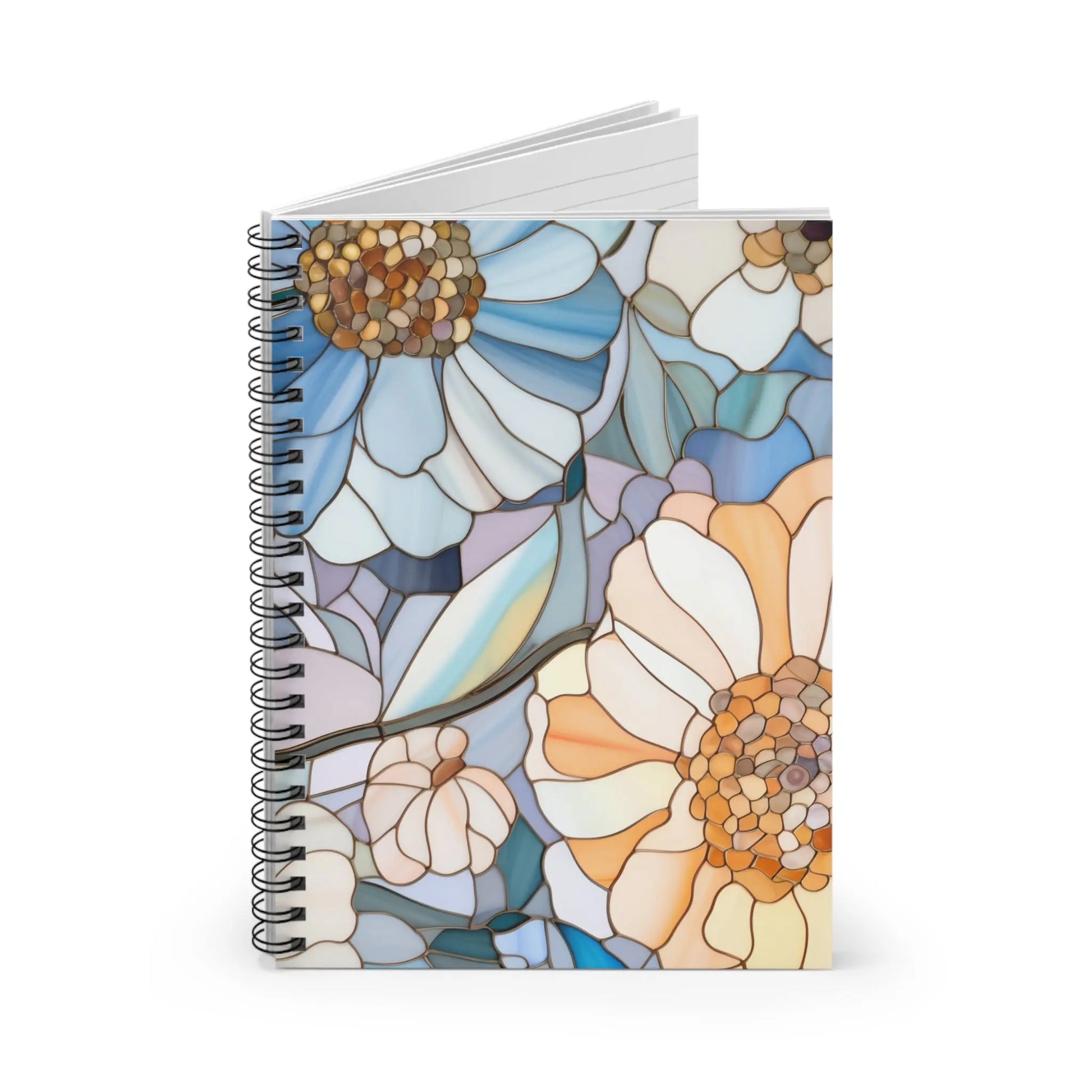 The Stained Glass Flowers Spiral Notebook features a bespoke cover resembling stained glass art, showcasing large flowers in blue, white, peach, and tan on a subtle background. The notebook has spiral binding with pages that open slightly when it stands upright.