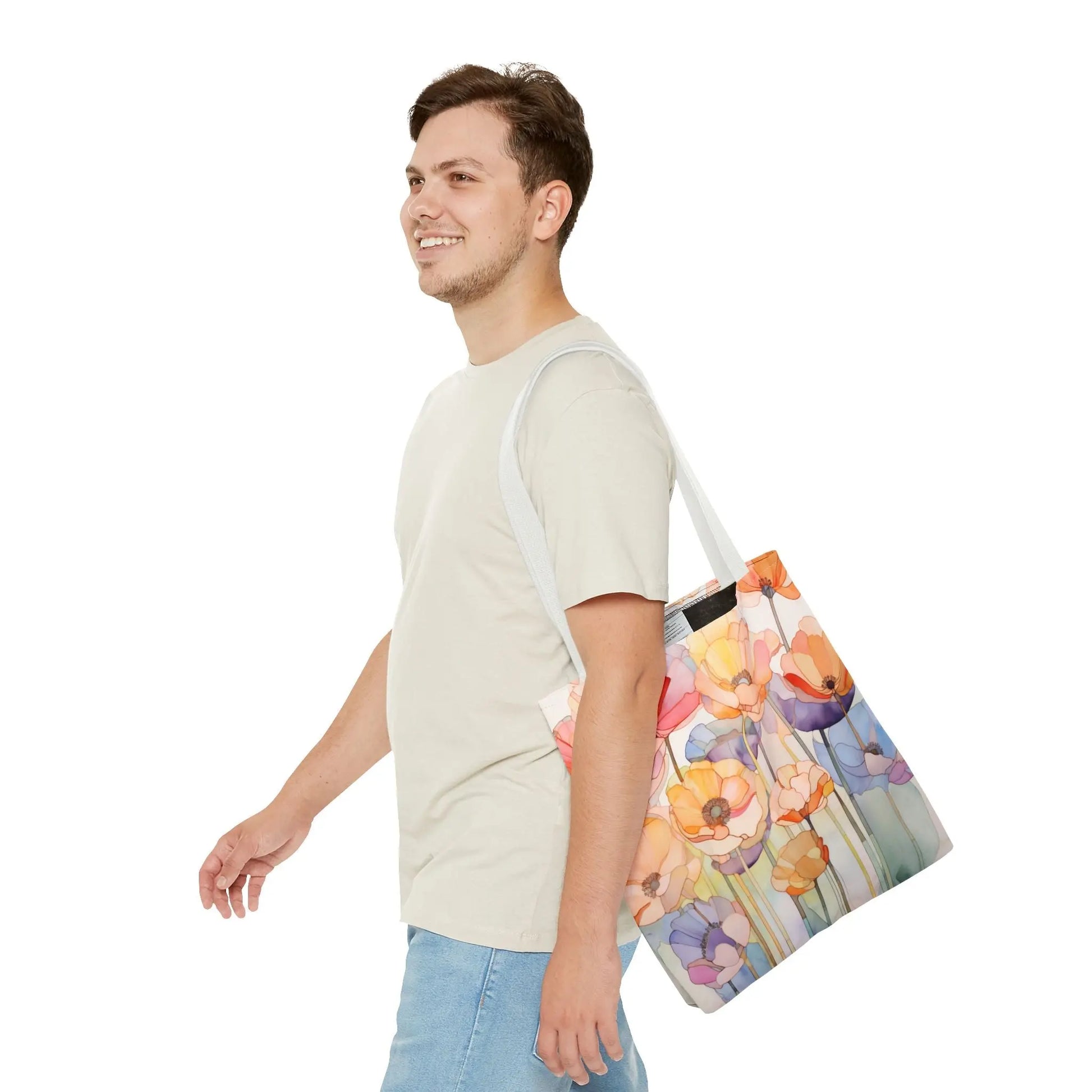 A person in a light grey t-shirt and light blue jeans carries the Stained Glass Poppy Flowers Tote Bag on their shoulder, smiling as they walk to the left against a plain white background.