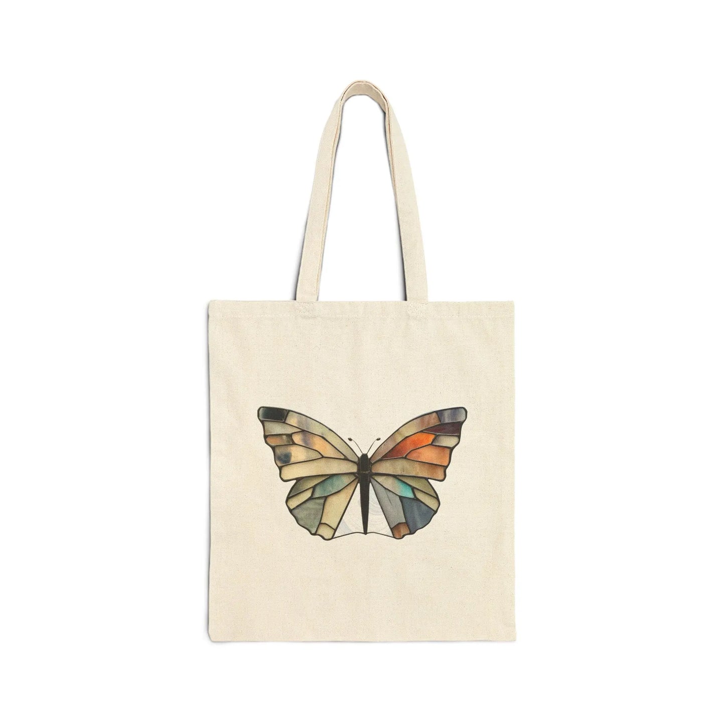 The Stained Glass Summer Butterfly Cotton Canvas Tote Bag, designed by Noelle Barnes, showcases a colorful butterfly with geometric orange, green, and blue patterns on a beige canvas. It features two sturdy handles and is attractively presented against a white backdrop.