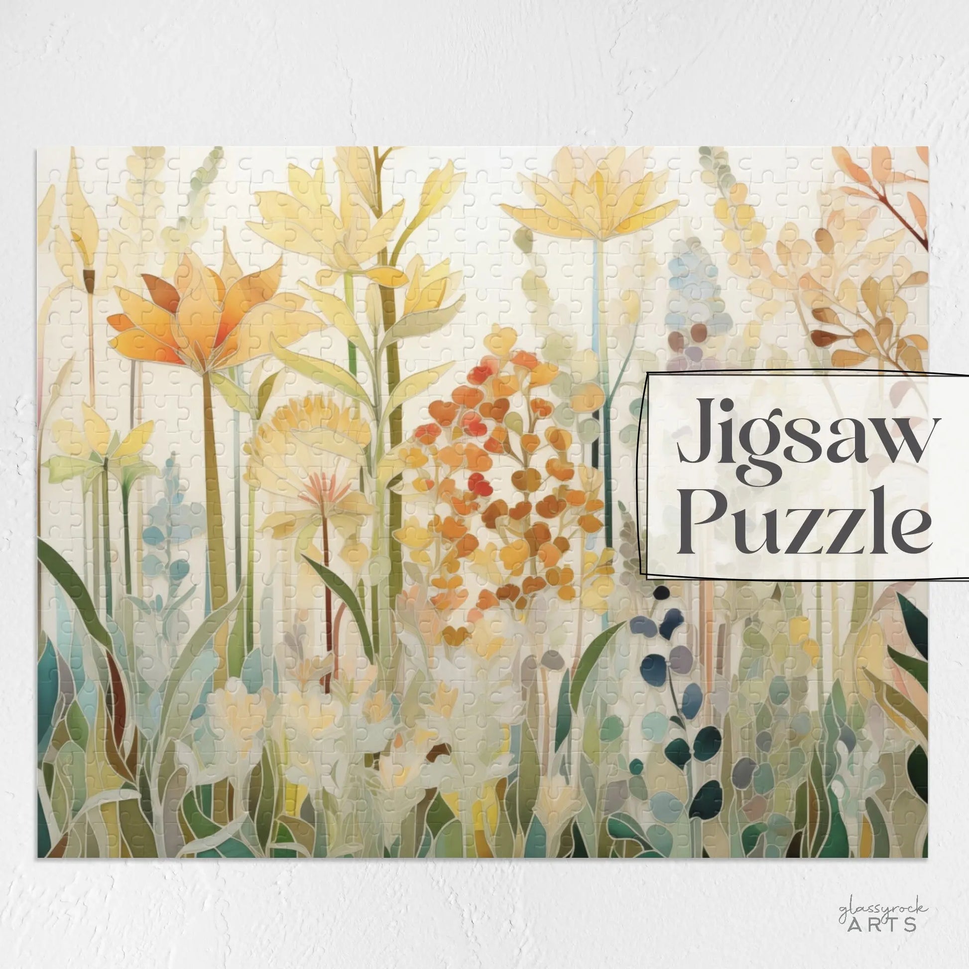 The Autumn Botanicals Jigsaw Puzzle features a vibrant display of yellow, orange, and green flowers arranged on a white background. The words Jigsaw Puzzle are elegantly written on the right side, making it a perfect art gift.
