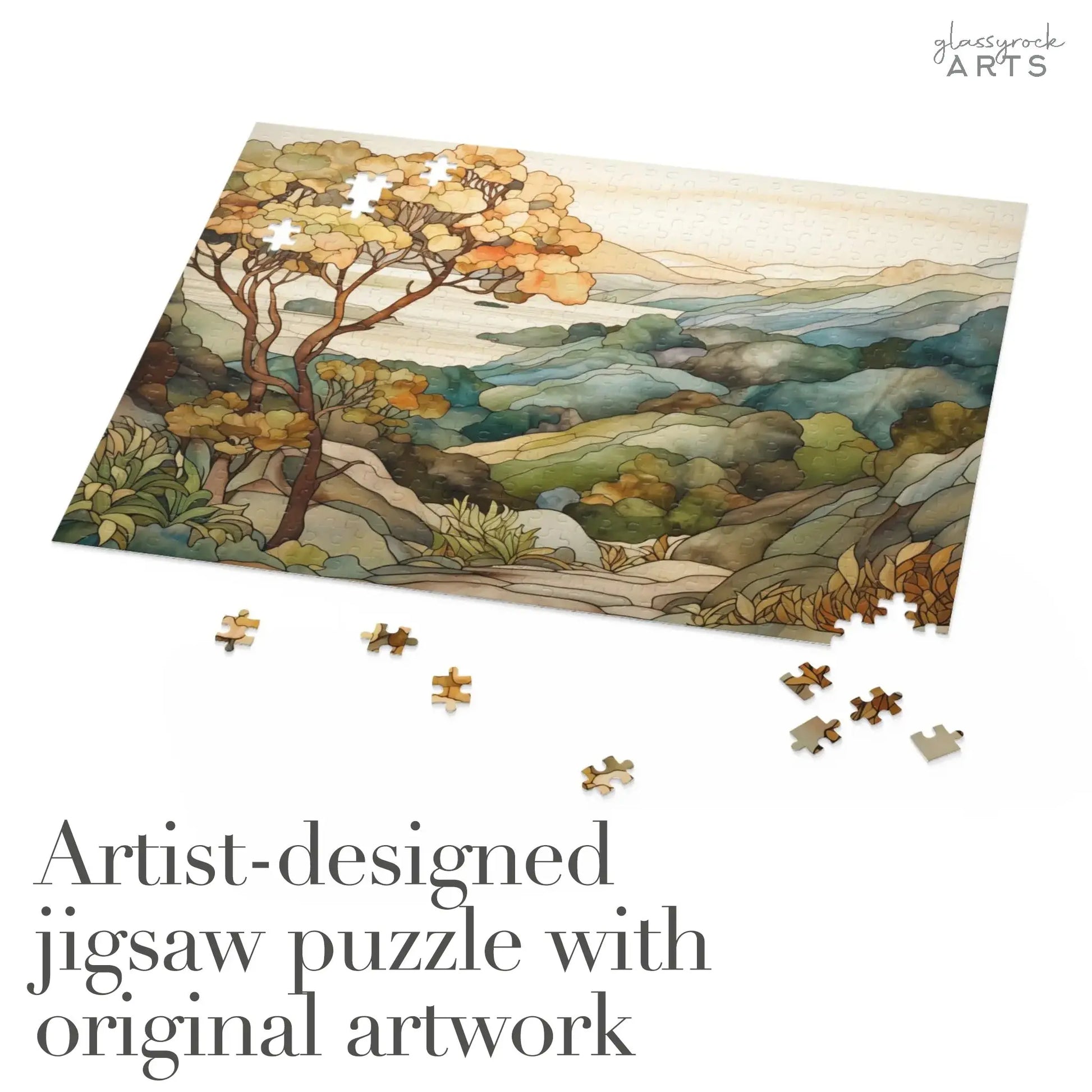A partially completed Big Sur California Coast Jigsaw Puzzle showcases a serene landscape with trees and hills in muted colors. Pieces are scattered around, and the text reads Artist-designed jigsaw puzzle with original artwork at the bottom.