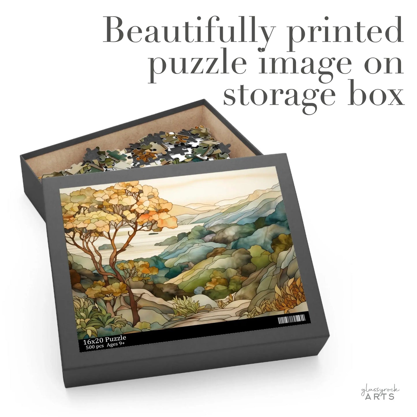 The 16x20 Big Sur California Coast Jigsaw Puzzle showcases a scenic landscape of hills and trees in a colorful, abstract style, akin to stained glass. An open box reveals the beautifully printed puzzle image and bears the text Beautifully printed puzzle image on storage box.