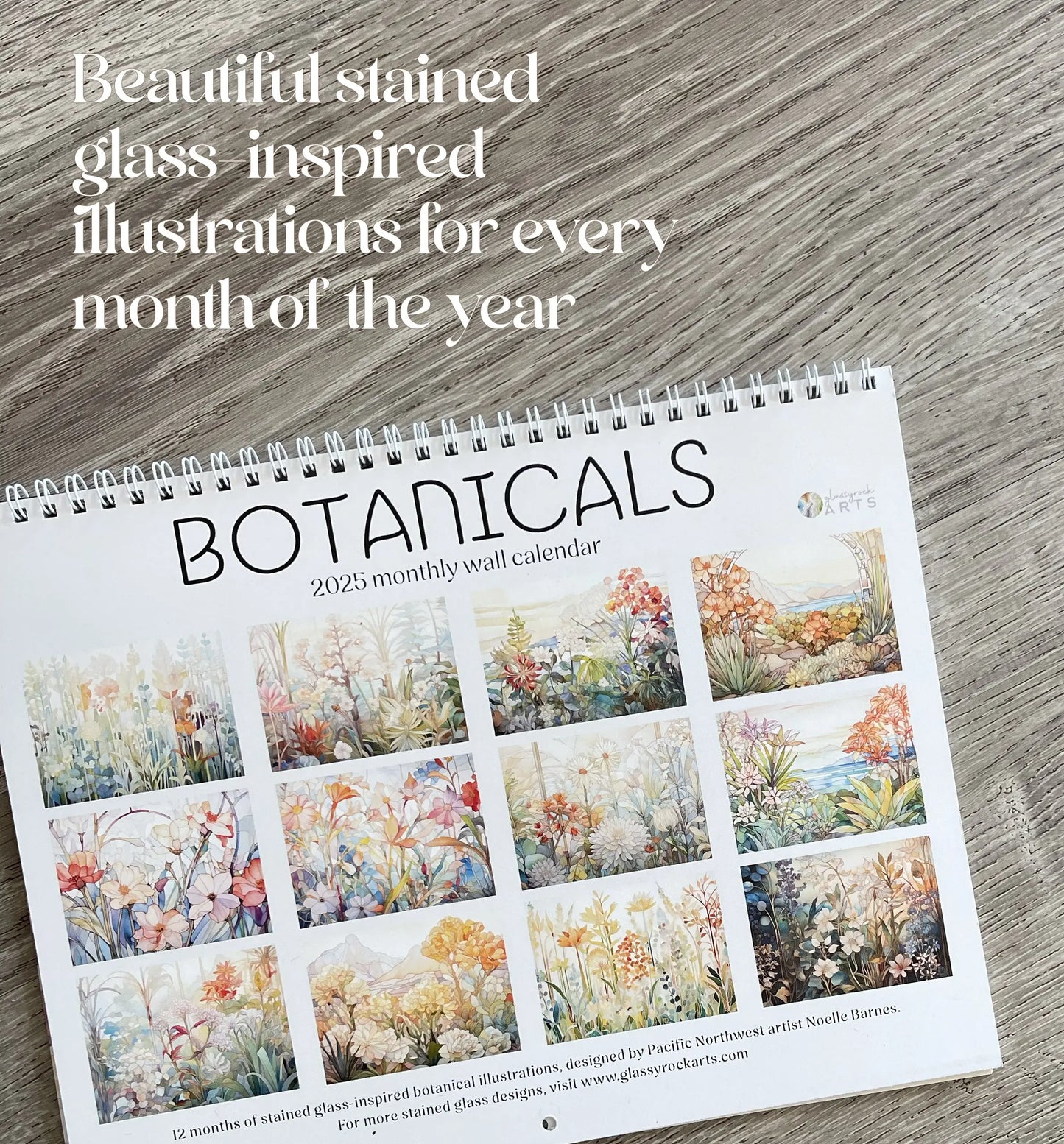 The 2025 Botanicals Wall Calendar graces a wooden surface with 12 stained glass-inspired botanical illustrations, one for each month. Elegant text above reads, Beautiful stained glass inspired illustrations for every month of the year.