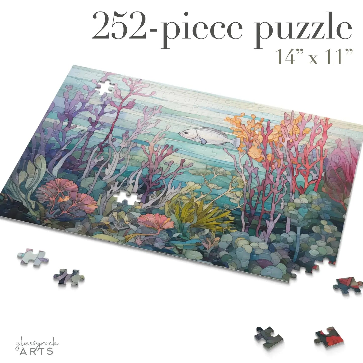 A partially completed Coral Reef Ocean Jigsaw Puzzle displays a vibrant coral reef scene with a fish. It has 252 pieces, measures 14 x 11, and features glassrock ARTS at the bottom left, making it perfect as an art gift. Some pieces are scattered around.