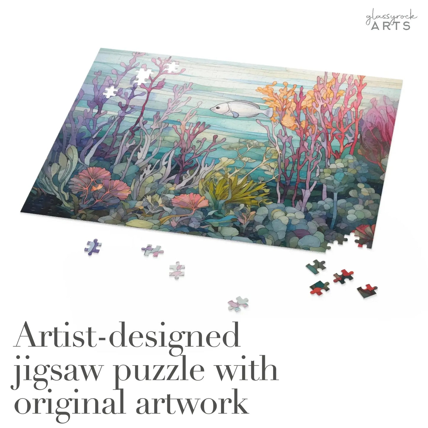 The partially completed Coral Reef Ocean Jigsaw Puzzle displays an underwater scene with vibrant corals and a fish. Loose pieces are scattered nearby. Text reads: Artist-designed puzzle featuring original artwork, ideal as an art gift.