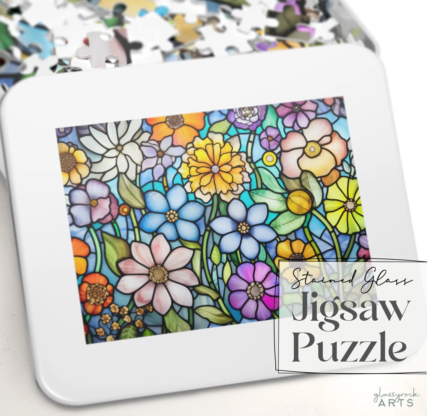 A vibrant stained glass puzzle showcases blooming daisies and roses amid green leaves. High-quality chipboard pieces are partially assembled on a white surface. Text reads Stained Glass Flower Garden Jigsaw Puzzle by Glasswork Arts—an ideal puzzle gift.