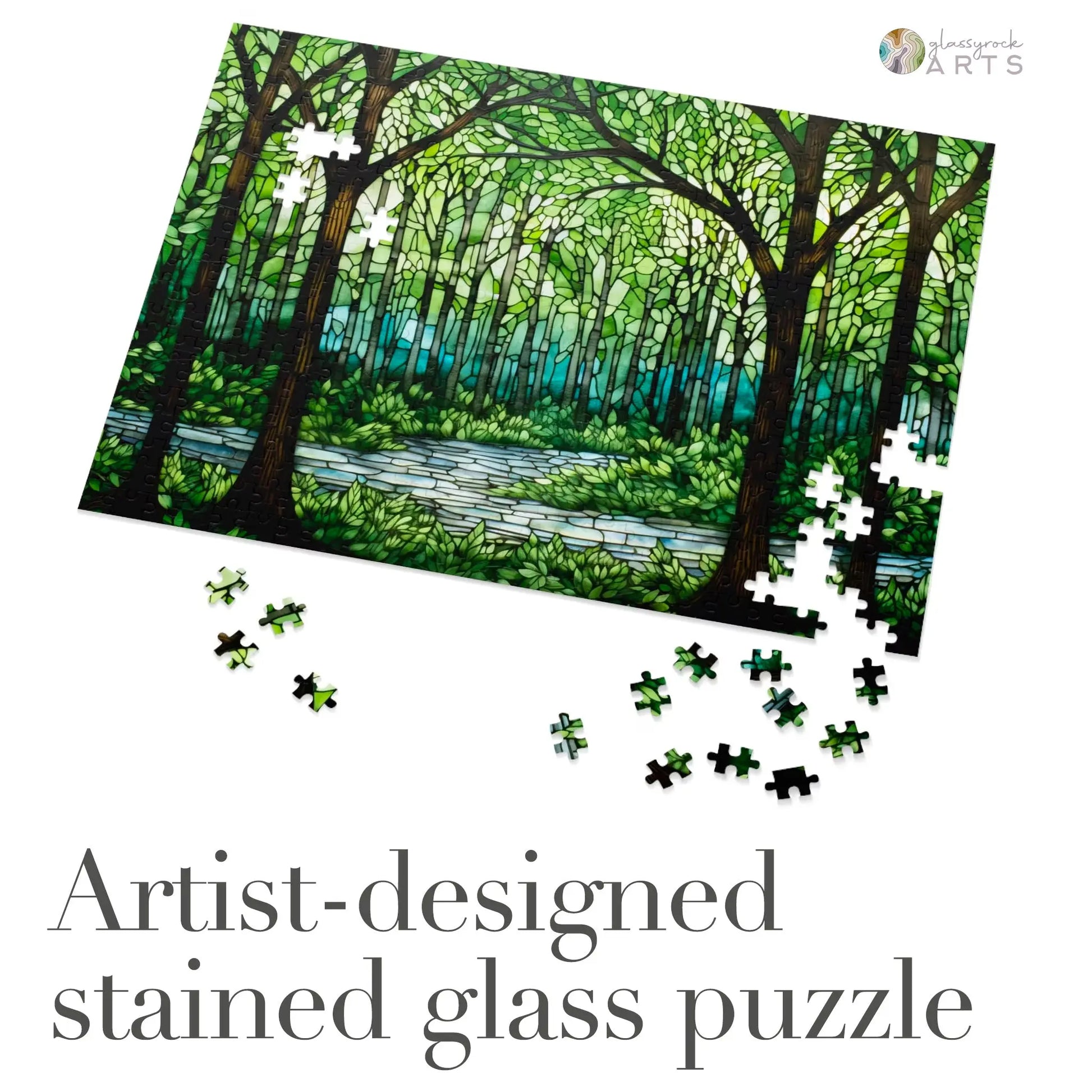 The Stained Glass Forest Jigsaw Puzzle features a breathtaking stained glass design of tall trees and a river in a lush forest. Scatter pieces to reveal the masterpiece. Text: Artist-designed.