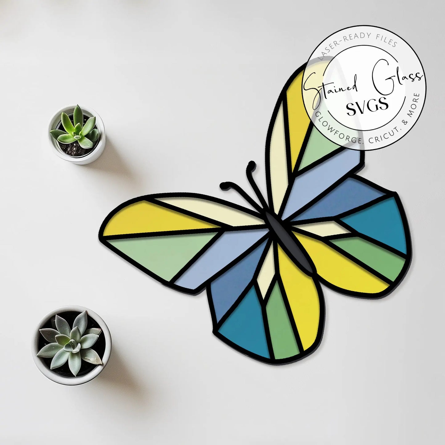Stained glass butterfly art piece with a geometric butterfly SVG in blue, green, and yellow on white. Accompanied by two small potted succulents. Top-right circle text: Stained Glass Geometric Butterfly SVGs.