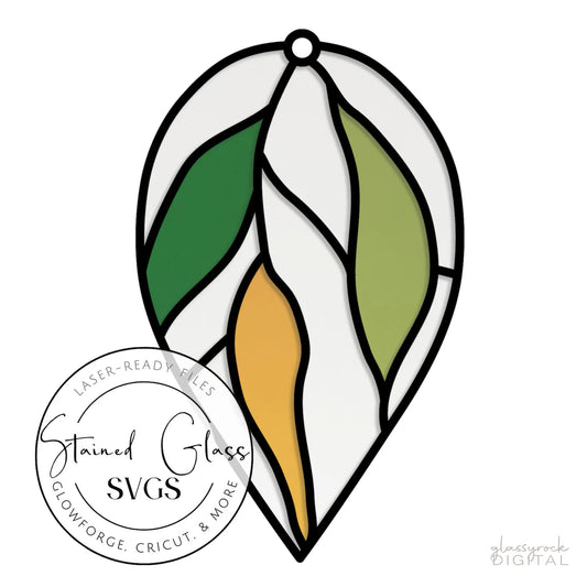 This Glowforge project is an illustration of a stained glass leaf ornament with vibrant sections in green, yellow, and white, featuring a circular label that reads Stained Glass SVGs. It includes laser cut files compatible with Cricut and more. Product: Stained Glass Hanging Leaves Teardrop SVGs.