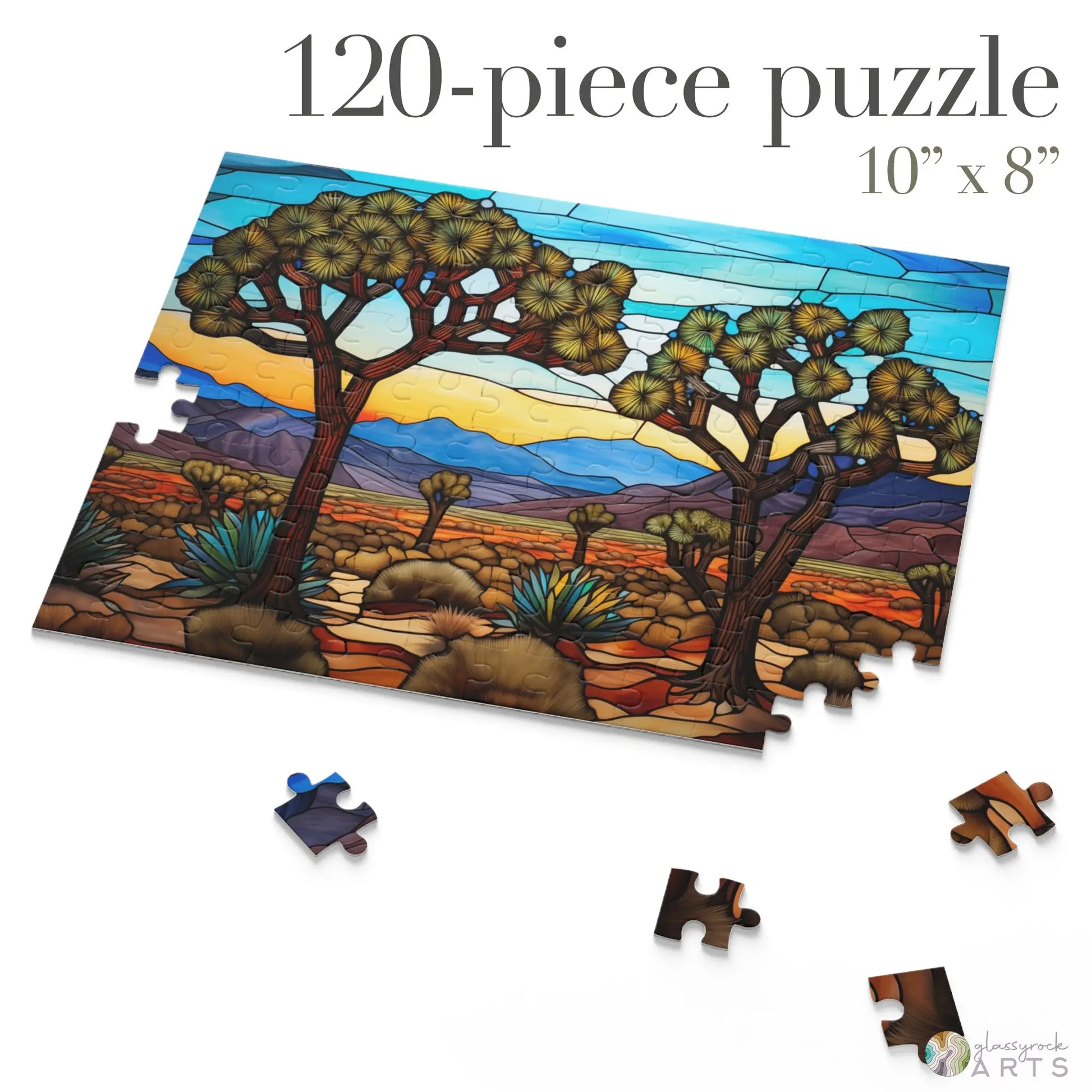 A partially completed 120-piece Joshua Tree National Park Jigsaw Puzzle showcases a vibrant desert landscape like stained glass, featuring trees and mountains. Measuring 10x8 inches, this artistic gift beautifully captures the parks essence, with a few loose pieces scattered around.