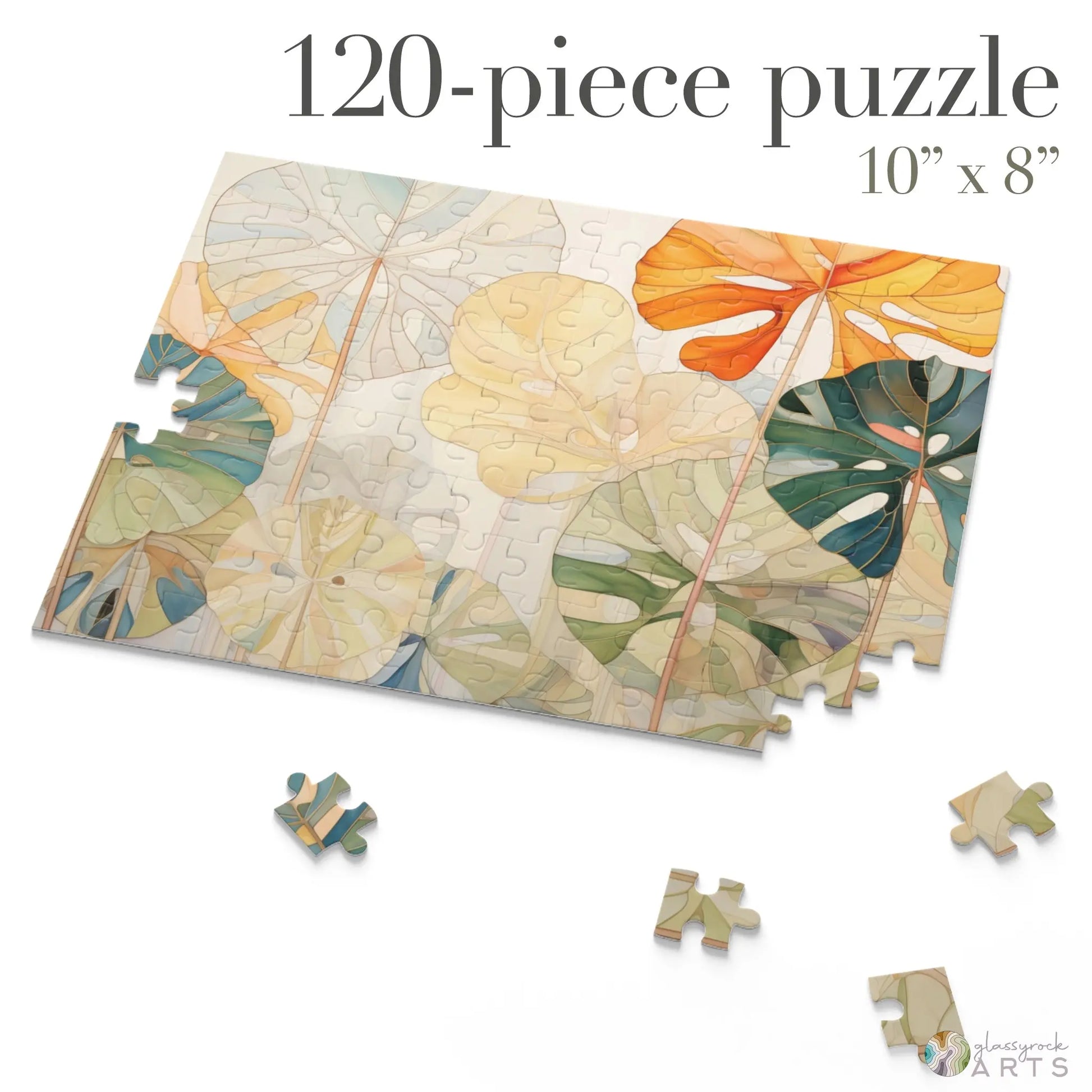 The Stained Glass Monstera Leaves Jigsaw Puzzle features 120 pieces forming a vibrant 10 x 8 design with colorful monstera leaves in orange, green, and cream. A perfect art gift or unique present for a couple.