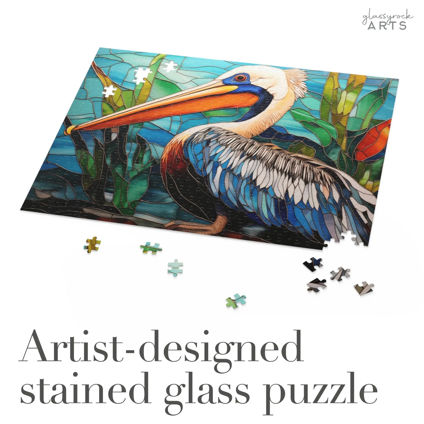 The Stained Glass Pelican Jigsaw Puzzle showcases a pelican with water and foliage, making it a perfect art gift or unique couples gift. Scattered pieces complete the design, while Artist-designed stained glass puzzle is inscribed below.