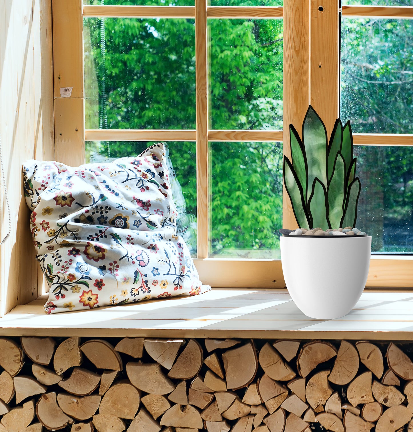 A cozy windowsill has a floral-patterned cushion and a potted plant. Sunlight streams through the wooden-framed window, highlighting the hues of the 3D Snake Plant Leaves Stained Glass Pattern. Below, logs are neatly stacked, with lush green foliage visible outside.