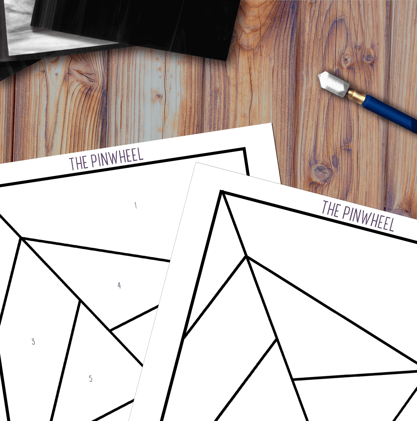 Two Abstract Rainbow Beginner Stained Glass Pattern templates rest on a wooden table for beginner projects. Nearby, a blue-handled utility knife is visible. The sheets have numbered triangular sections, suggesting a DIY craft or digital pattern download.