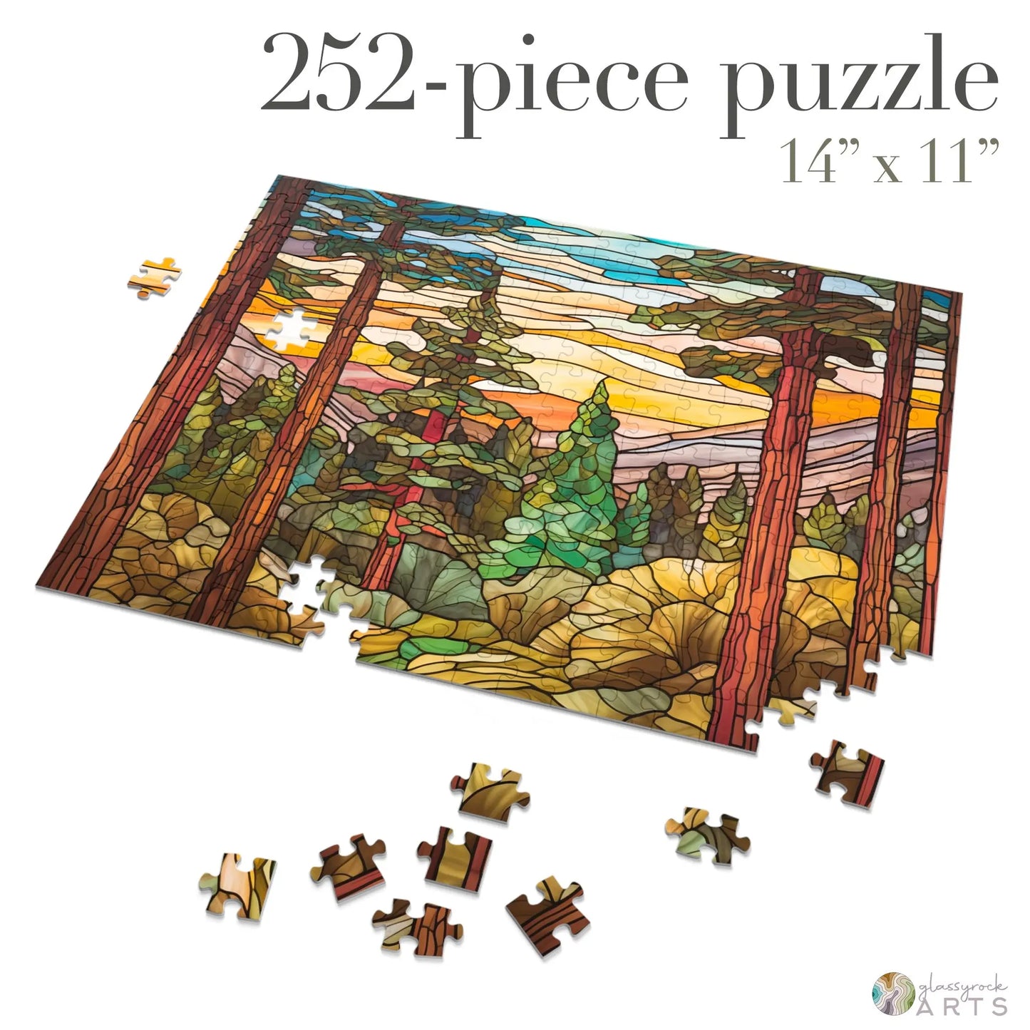 A 252-piece Stained Glass Sequoia Forest Jigsaw Puzzle shows a forest scene with tall trees and colorful foliage. The partially assembled puzzle has loose pieces scattered, with dimensions of 14 x 11. It comes in a gift-ready metal box, ideal for puzzle enthusiasts.