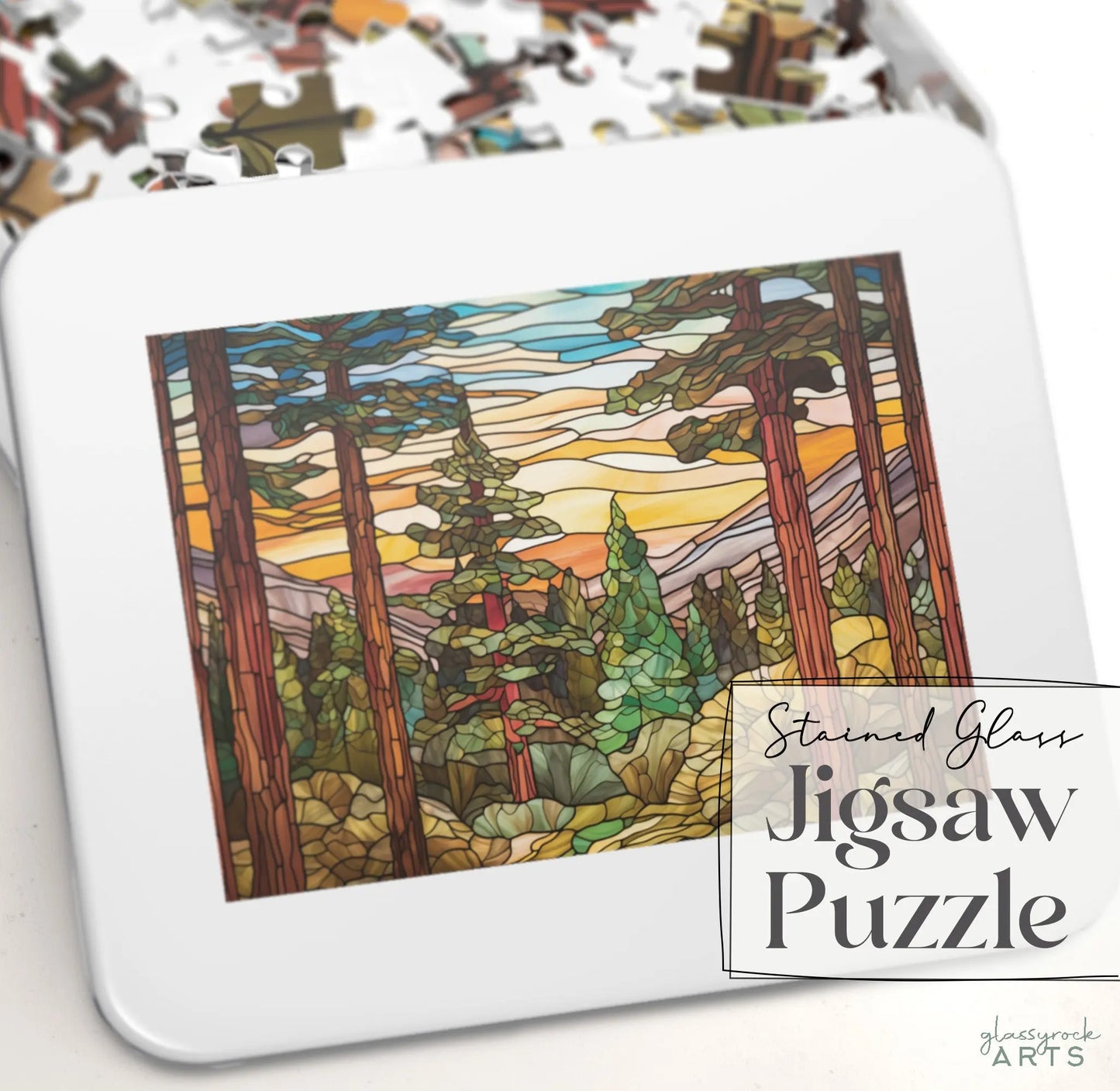 The Stained Glass Sequoia Forest Jigsaw Puzzle by Glassrack Arts features a scenic forest with tall trees under a vibrant sky. The pieces come in a gift-ready metal box labeled Stained Glass Jigsaw Puzzle.
