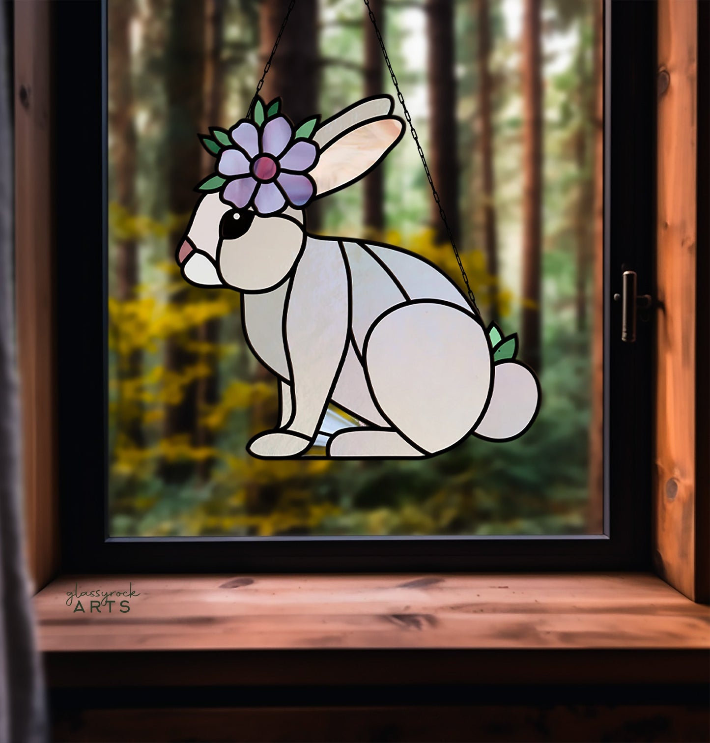 The Spring Rabbit Bunny Stained Glass Pattern features a bunny with a flower crown, perfect for a DIY Easter gift. Made from white and pastel glass, it reveals tall forest trees beyond, making it an enchanting spring suncatcher.