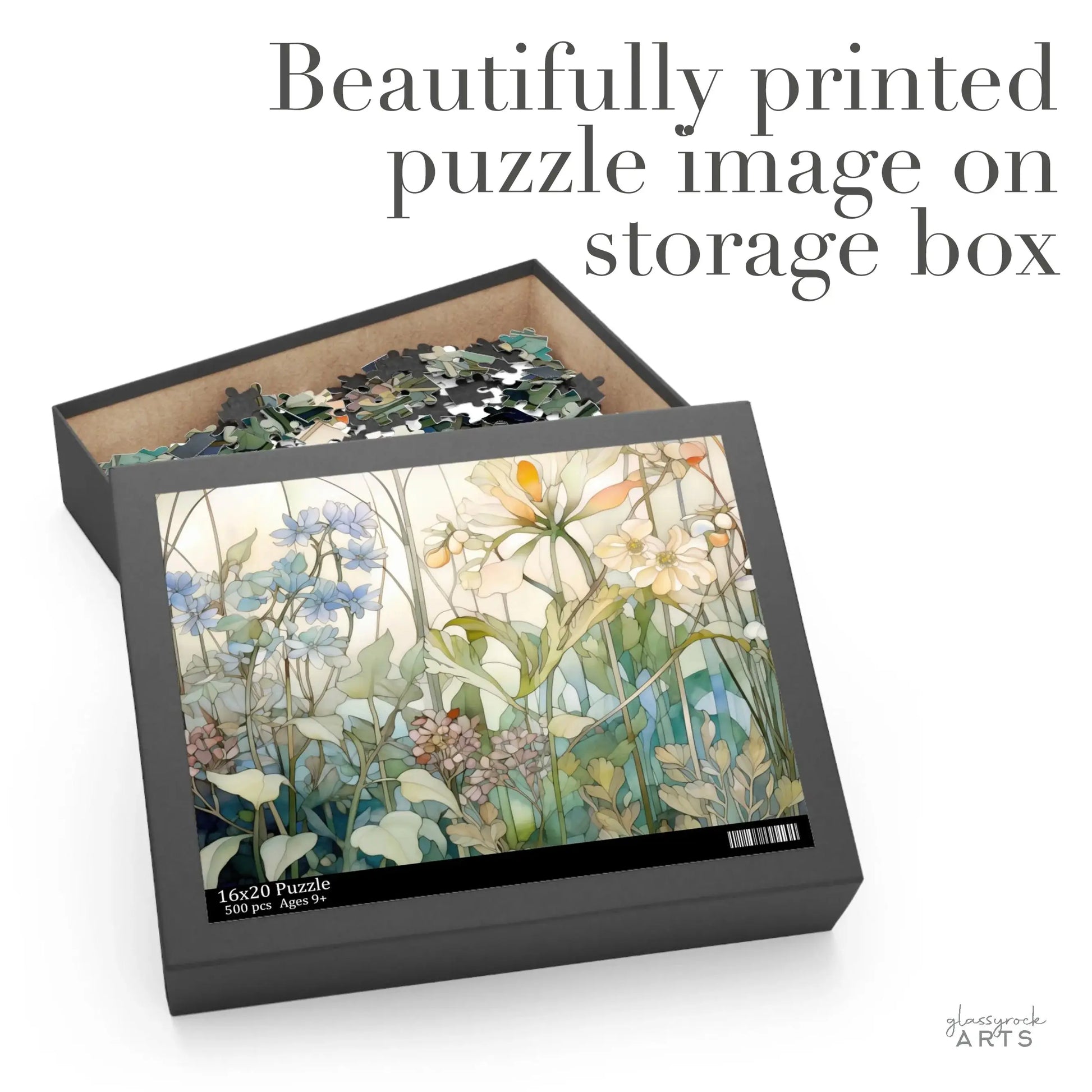 The Summer Wildflowers Jigsaw Puzzle box displays a colorful floral image on its lid, featuring white, yellow, and blue summer wildflowers with lush green leaves. The partially filled box with assorted pieces states: Beautifully printed puzzle image on storage box.