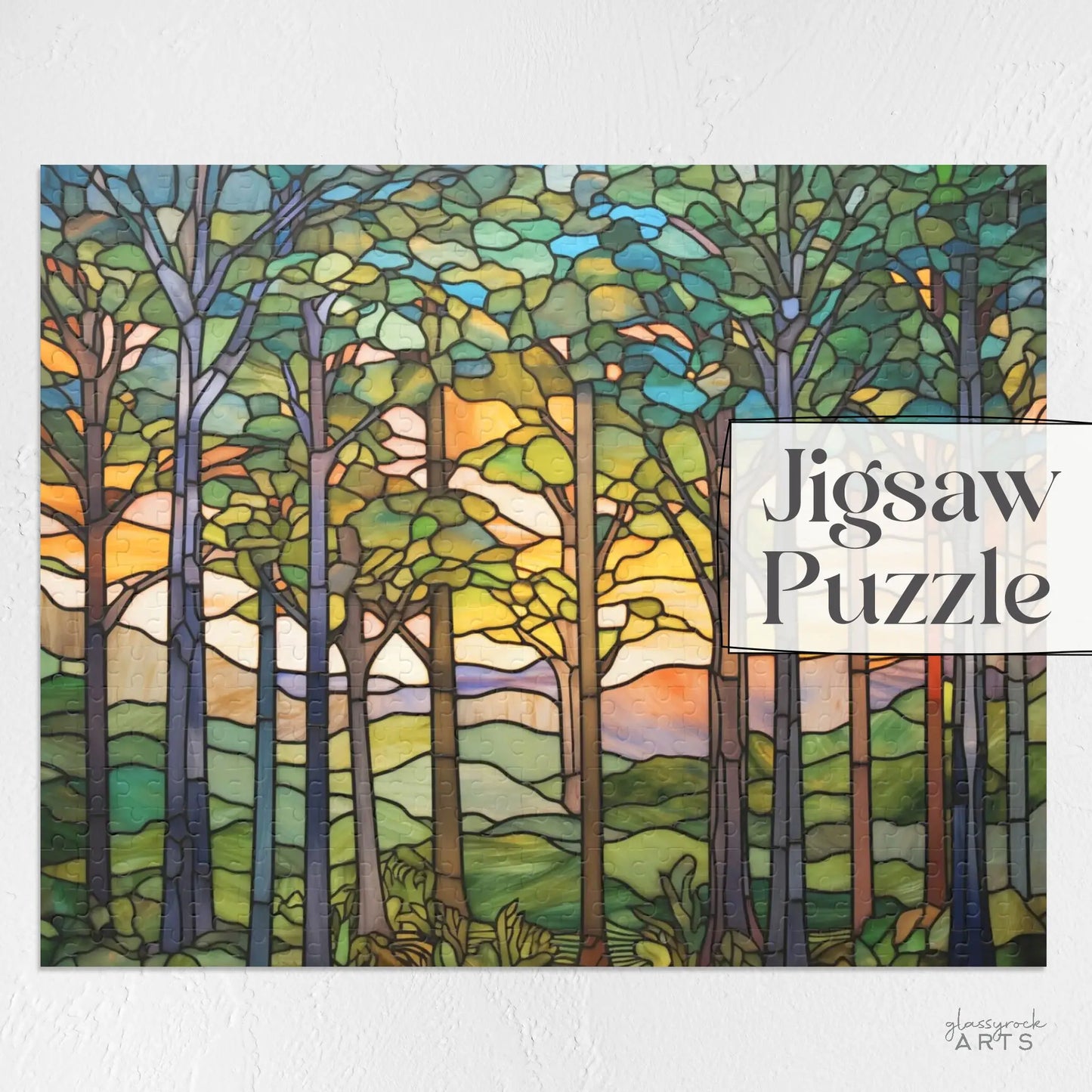 A stained glass-style artwork showing a sunset forest scene with tall trees, vibrant leaves, and a colorful sky. Its perfect for nature lovers and features the text Sunset Forest Jigsaw Puzzle on the right side.