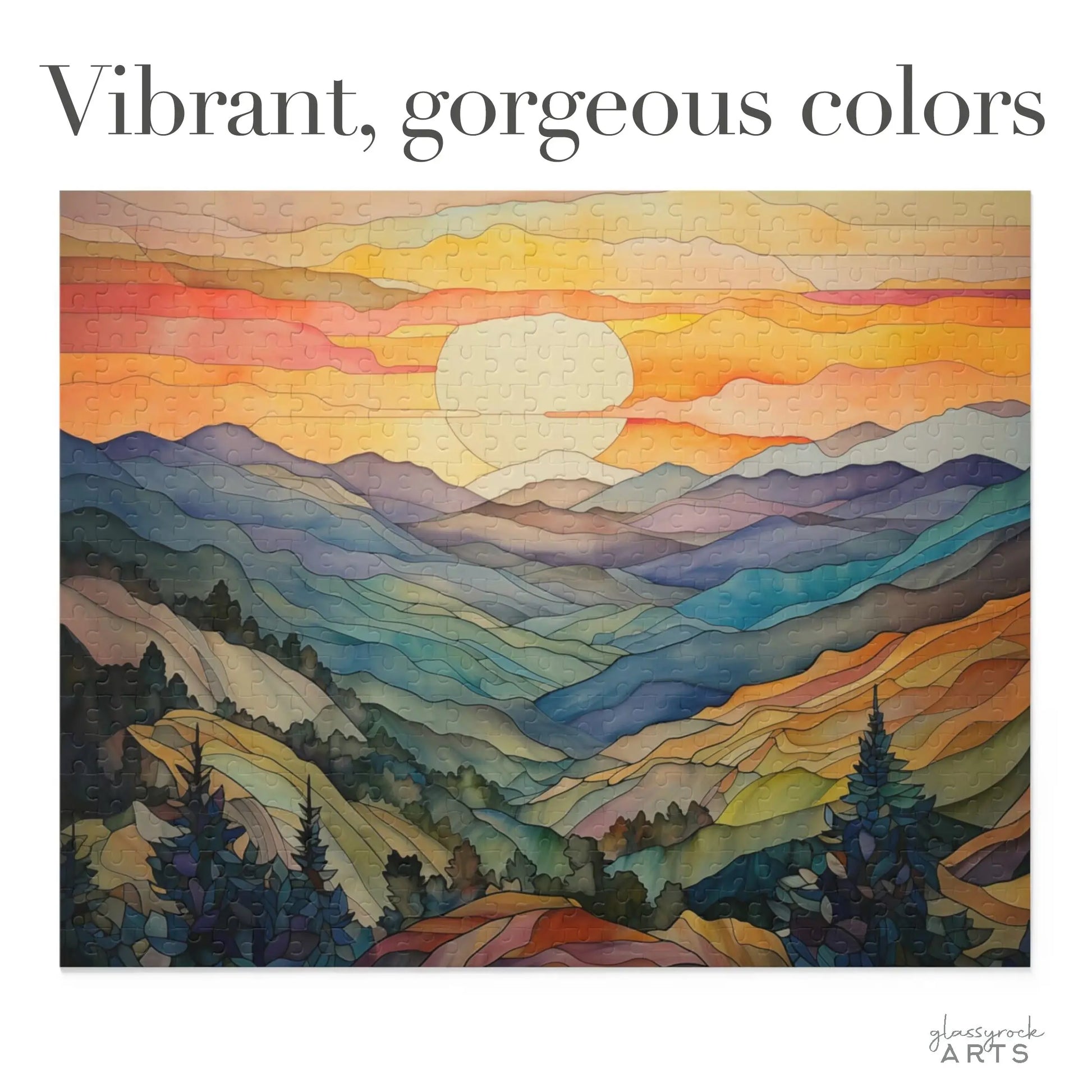 The Sunset Mountains Jigsaw Puzzle, ideal for nature lovers, features a landscape of rolling hills and mountains under a breathtaking sunset sky. The scene bursts with vibrant oranges, blues, and greens, highlighting lush trees in the foreground with Vibrant, gorgeous colors at the top.