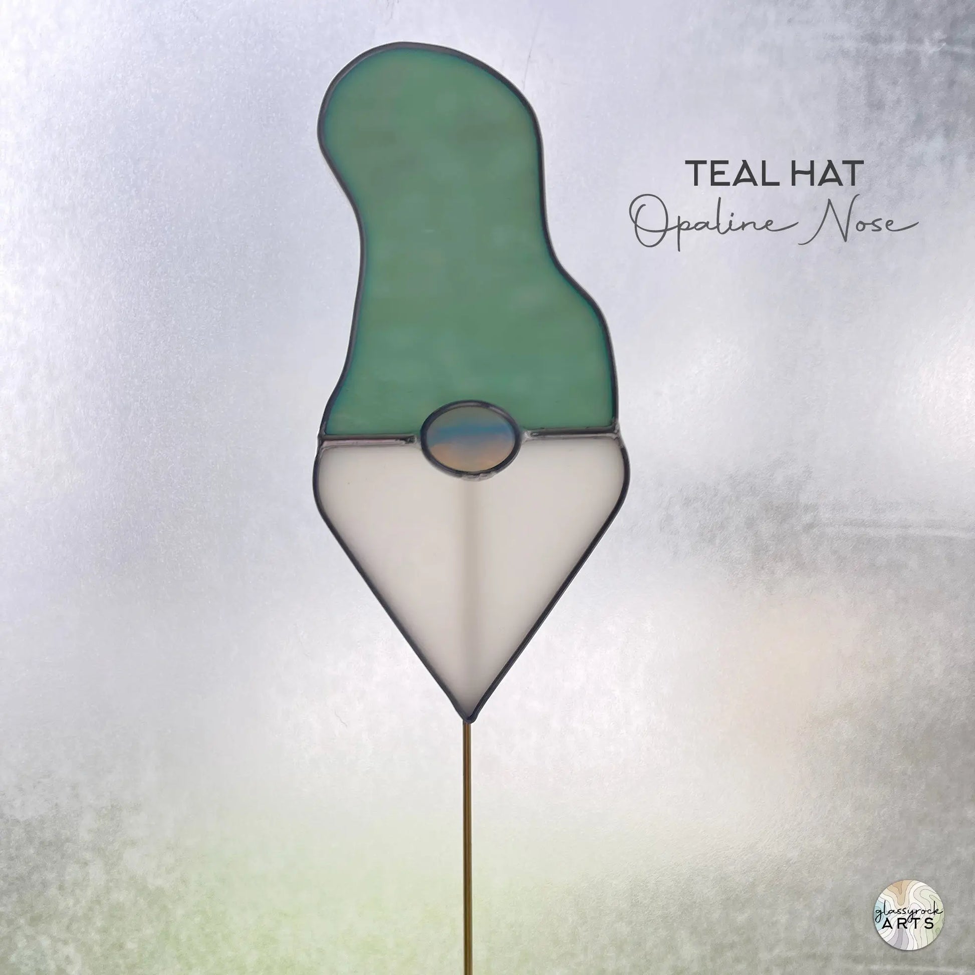 A picture of the Handmade Stained Glass Gnome Plant Stake - Teal Hat from GlassyRock Arts.