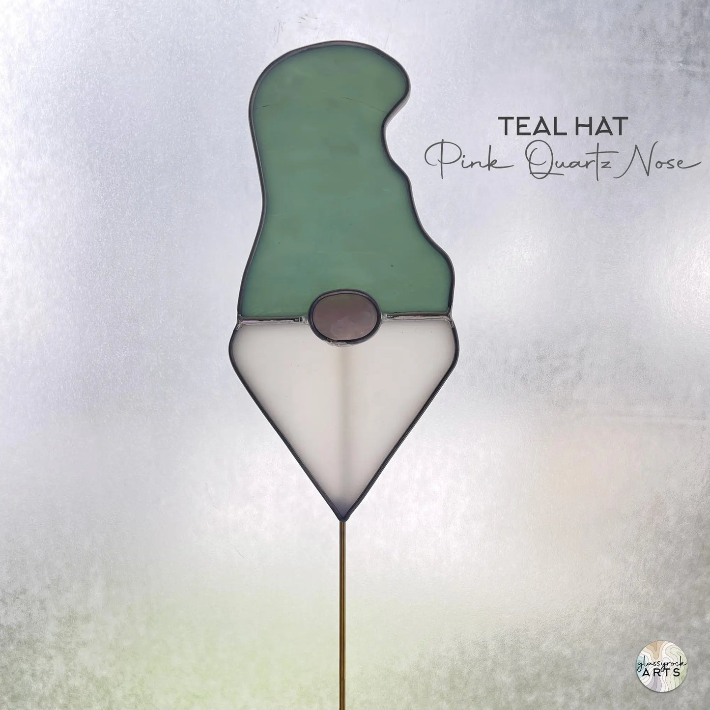 A picture of the Handmade Stained Glass Gnome Plant Stake - Teal Hat from GlassyRock Arts.