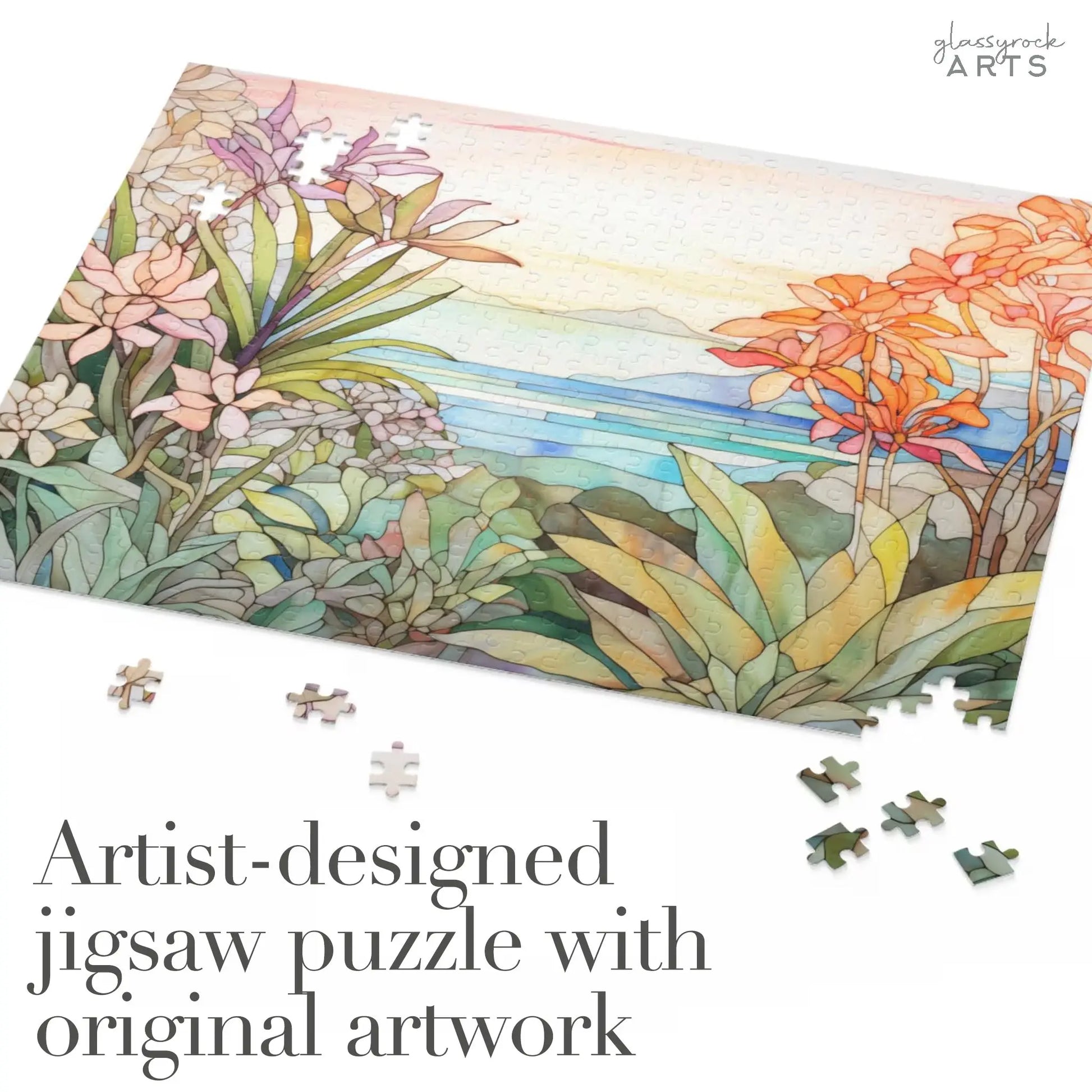 A scattered jigsaw puzzle, titled Tropical Botanicals, showcases original stained glass-inspired artwork of a colorful landscape with flowers and water. The text reads, Artist-designed jigsaw puzzle with original artwork.