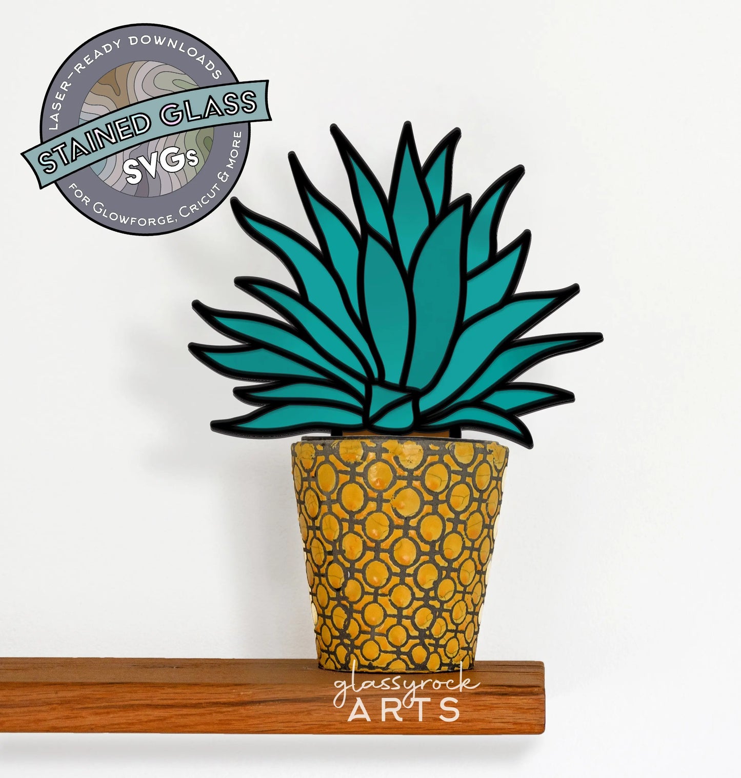 SVG illustration of a stylized teal agave plant in a textured yellow pot on a white background, with a wooden shelf below. Ideal DIY gift for plant lovers. A circular logo in the top left reads, Stained Glass SVGs. Product name: Stained Glass Agave Plant, SVG for Laser Cutting.