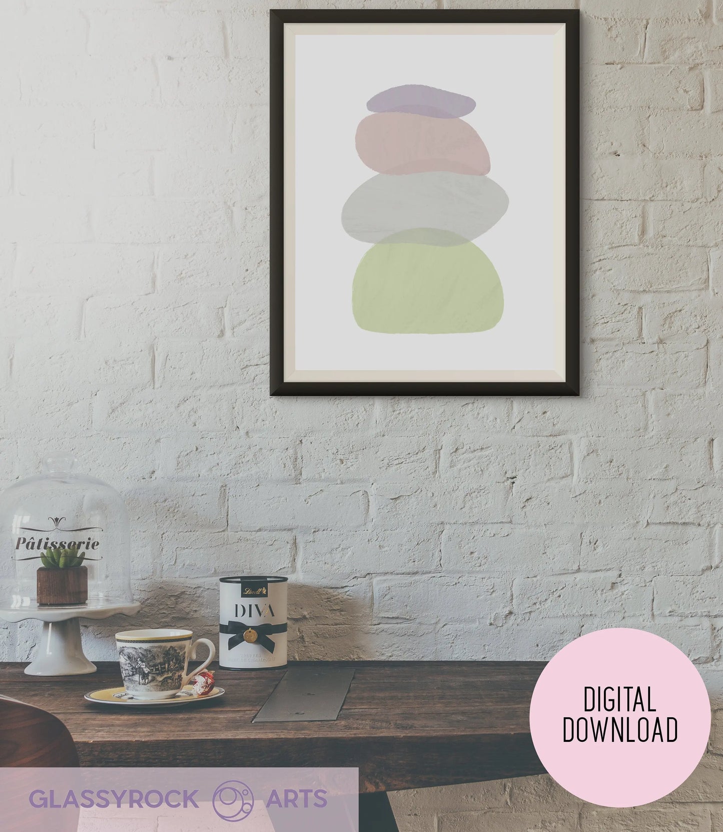 A cozy dining area features a wooden table against a white brick wall, adorned with the Pastel Painted Boho Stone Shapes Digital Art. On the table are a teapot, cup, glass jar with lid, and cake stand covered by a dome lid.
