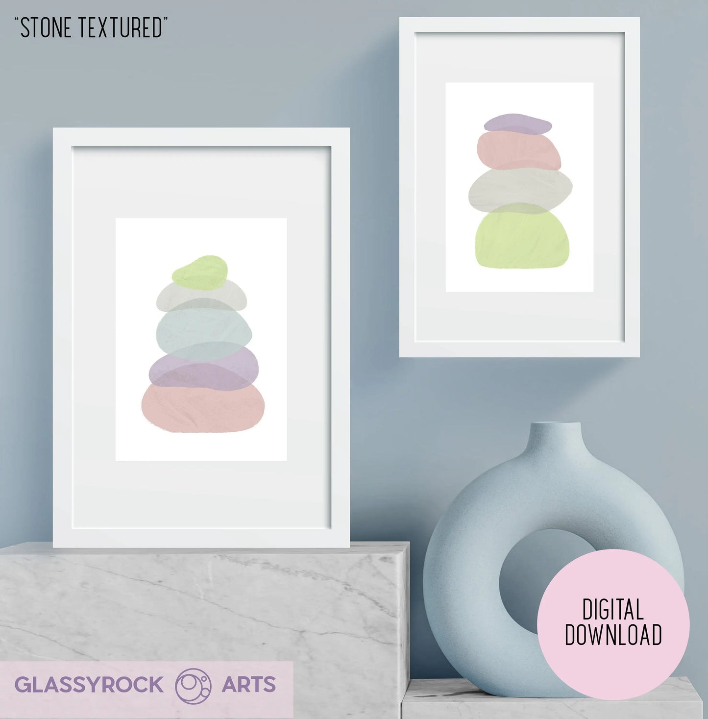 Two framed prints of Pastel Painted Boho Stone Shapes Digital Art decorate a light gray wall. A round light blue vase sits below on a gray surface. A pink circle saying Digital Download indicates instant digital file availability on the right side of the image.