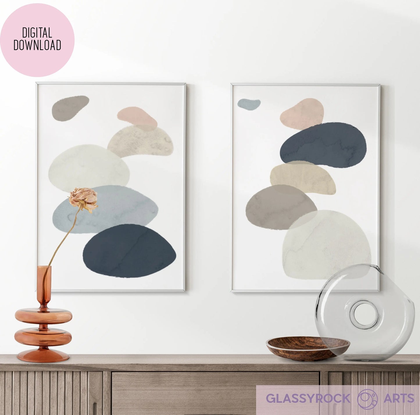 Framed Abstract Watercolor Stone Shapes Digital Art prints in neutral tones are displayed above a wooden console with a glass vase, flower, and round object. An Instant Digital File tag is visible.