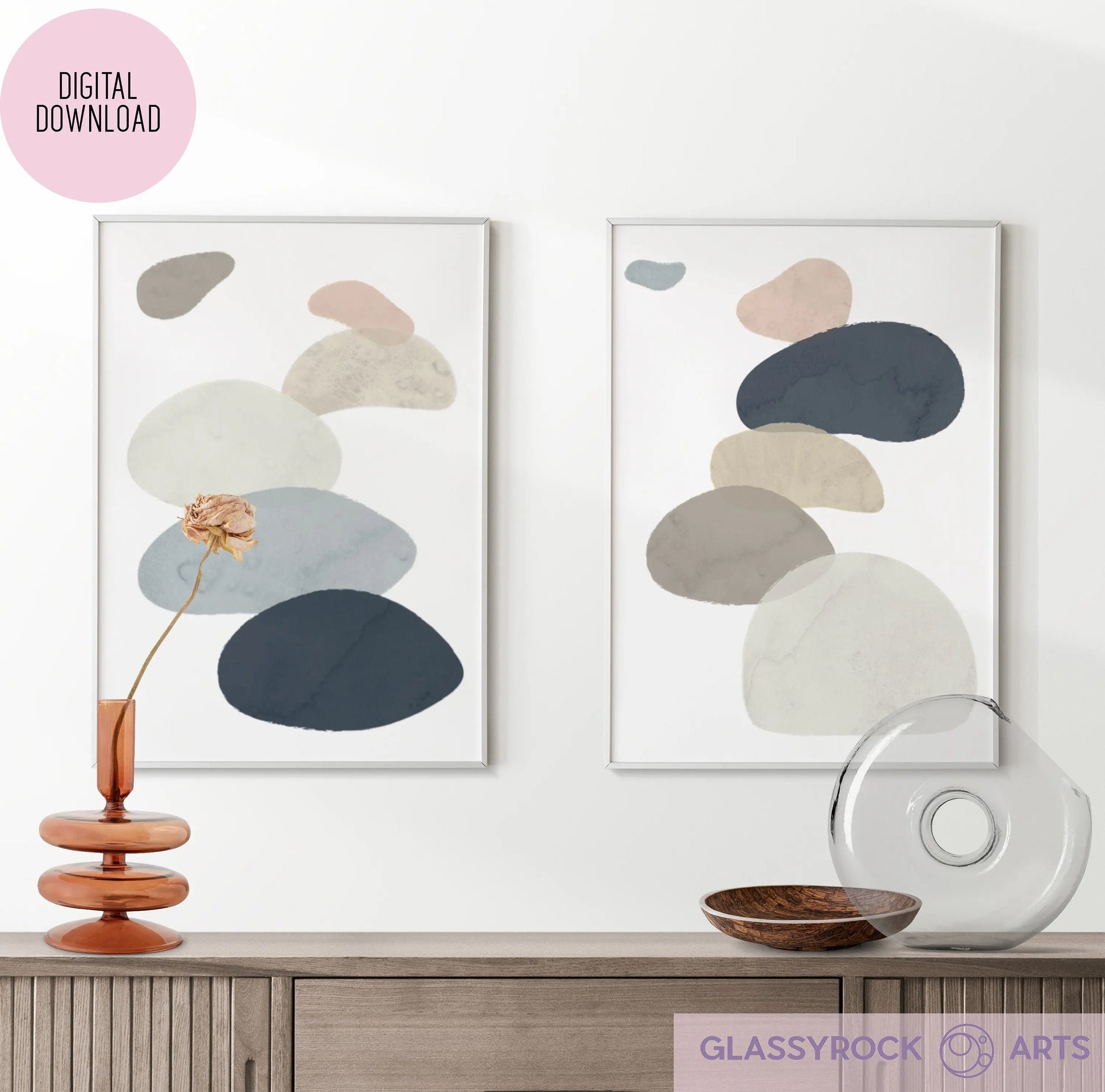 Framed Abstract Watercolor Stone Shapes Digital Art prints in neutral tones are displayed above a wooden console with a glass vase, flower, and round object. An Instant Digital File tag is visible.