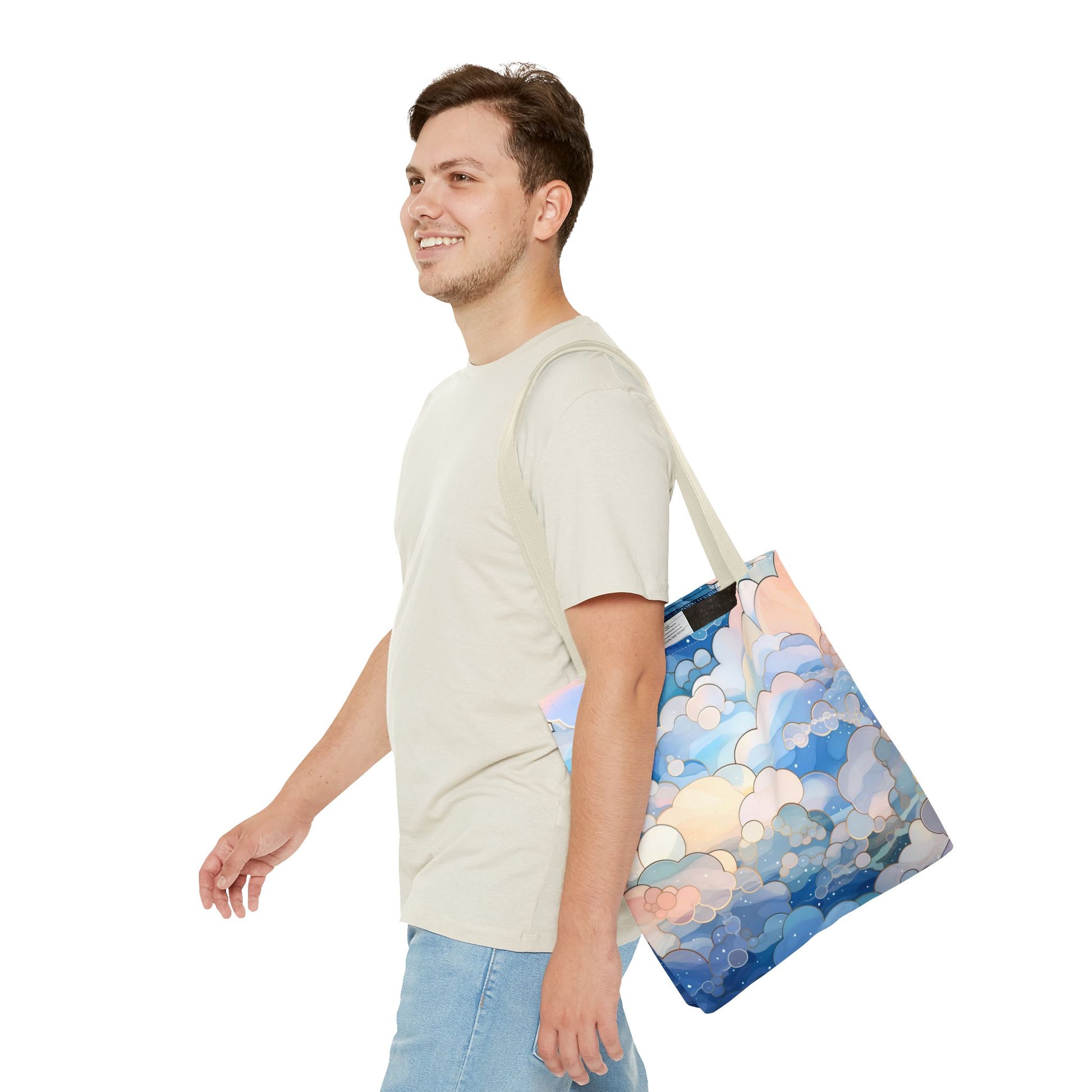 A person with short hair, wearing a light t-shirt and denim shorts, carries the durable Stained Glass Clouds Tote Bag featuring a groovy mushroom design with blue, pink, and white cloud-like shapes on a plain white background.