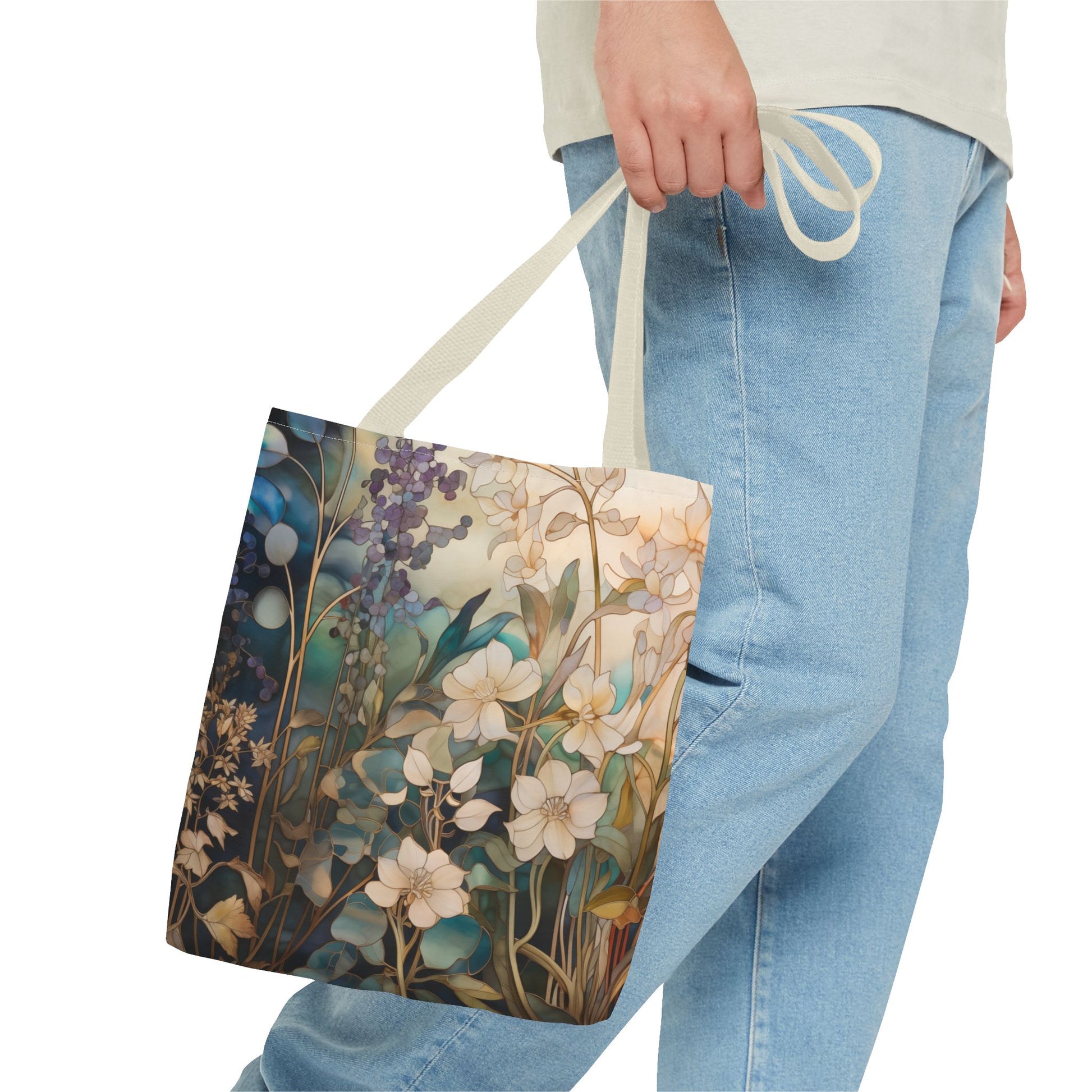 A person carries the Stained Glass Midnight Flowers Tote Bag, made from durable polyester with white and blue flowers and green leaves, perfectly pairing it with light blue jeans and a pale shirt for an effortlessly chic look.